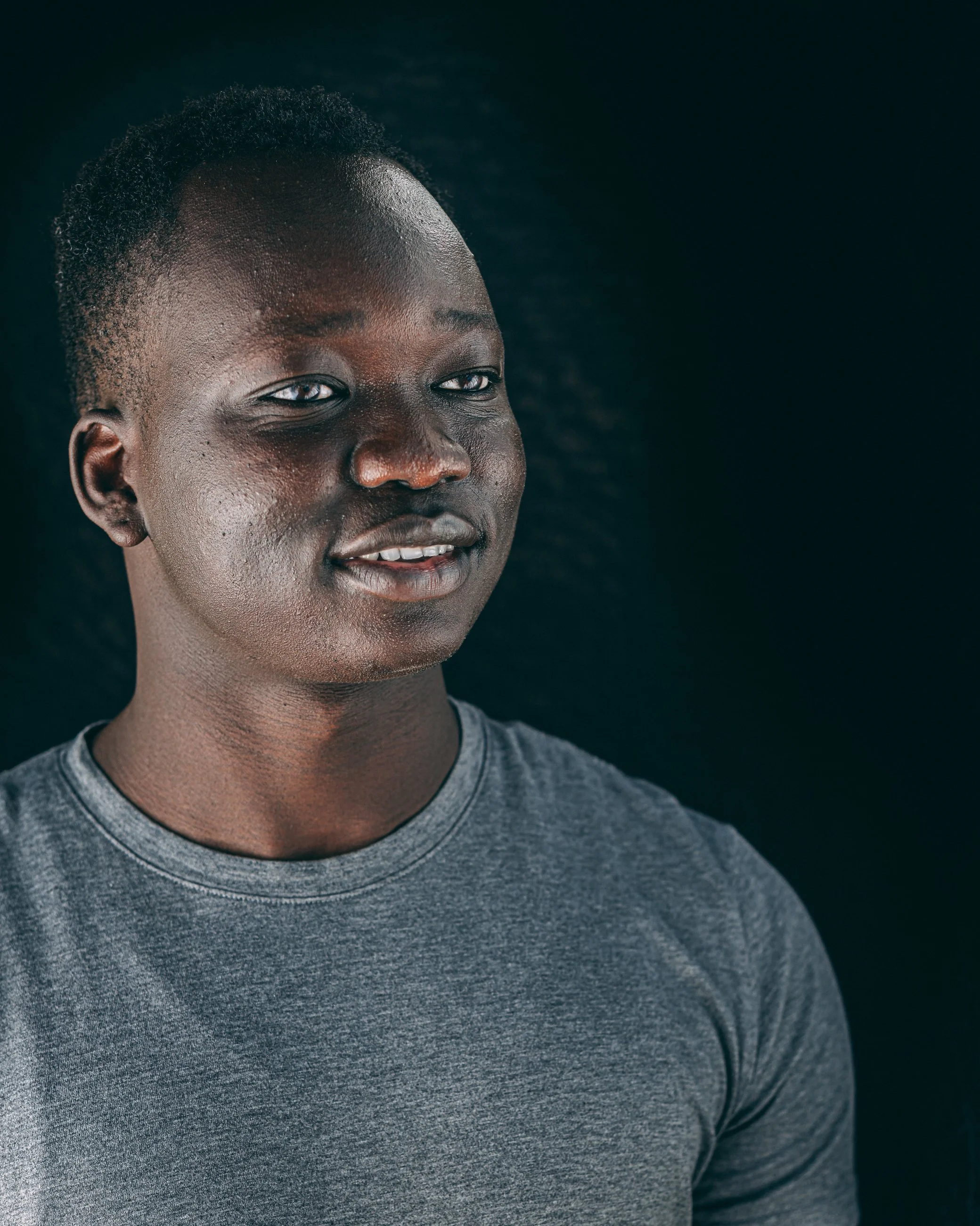 Smiling studio portrait of a man in a gray shirt, portrait photography by Everlux Photo Co.