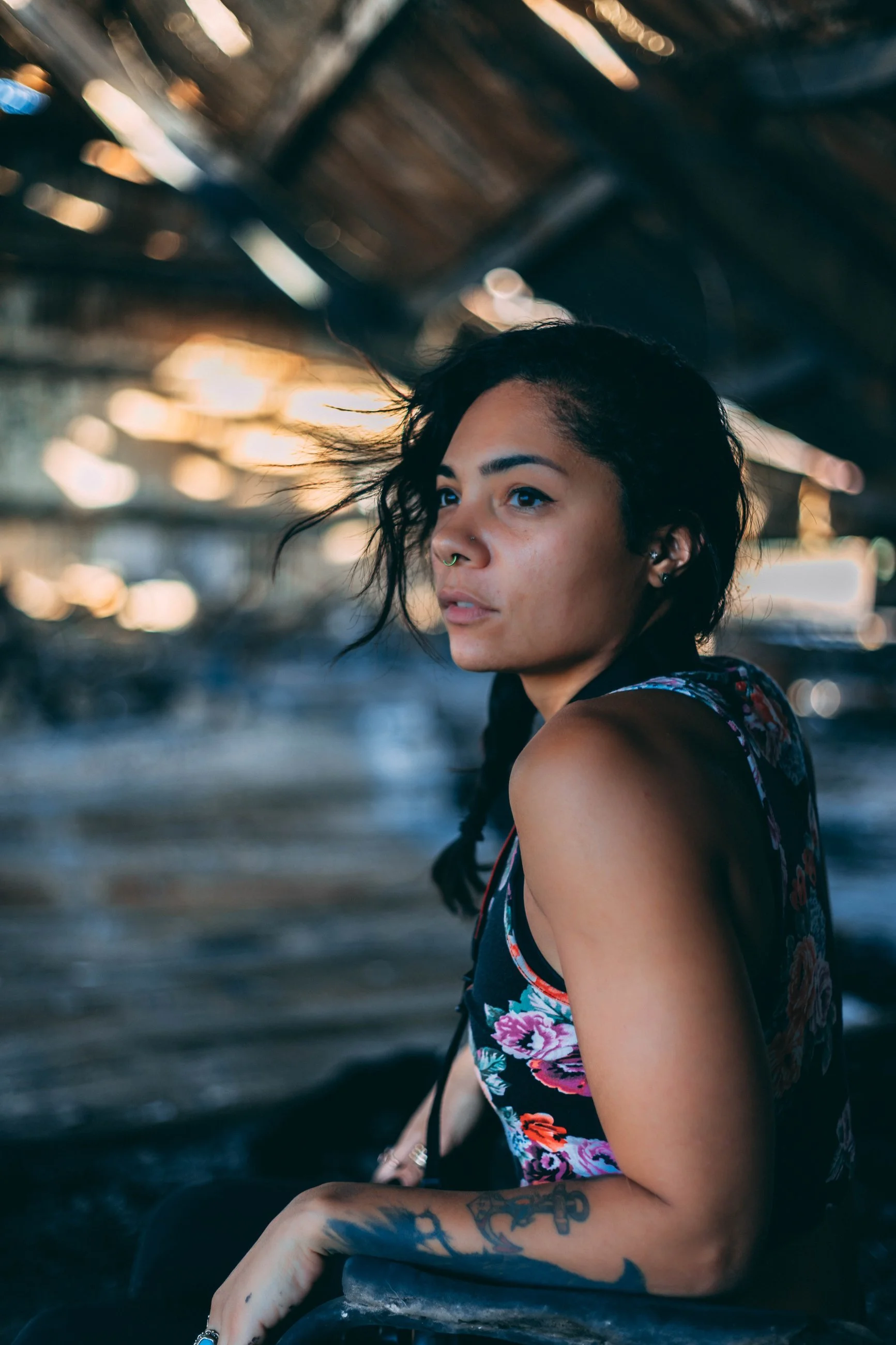 Moody portrait of a woman in a dimly lit indoor industrial setting, portrait photography by Everlux Photo Co.