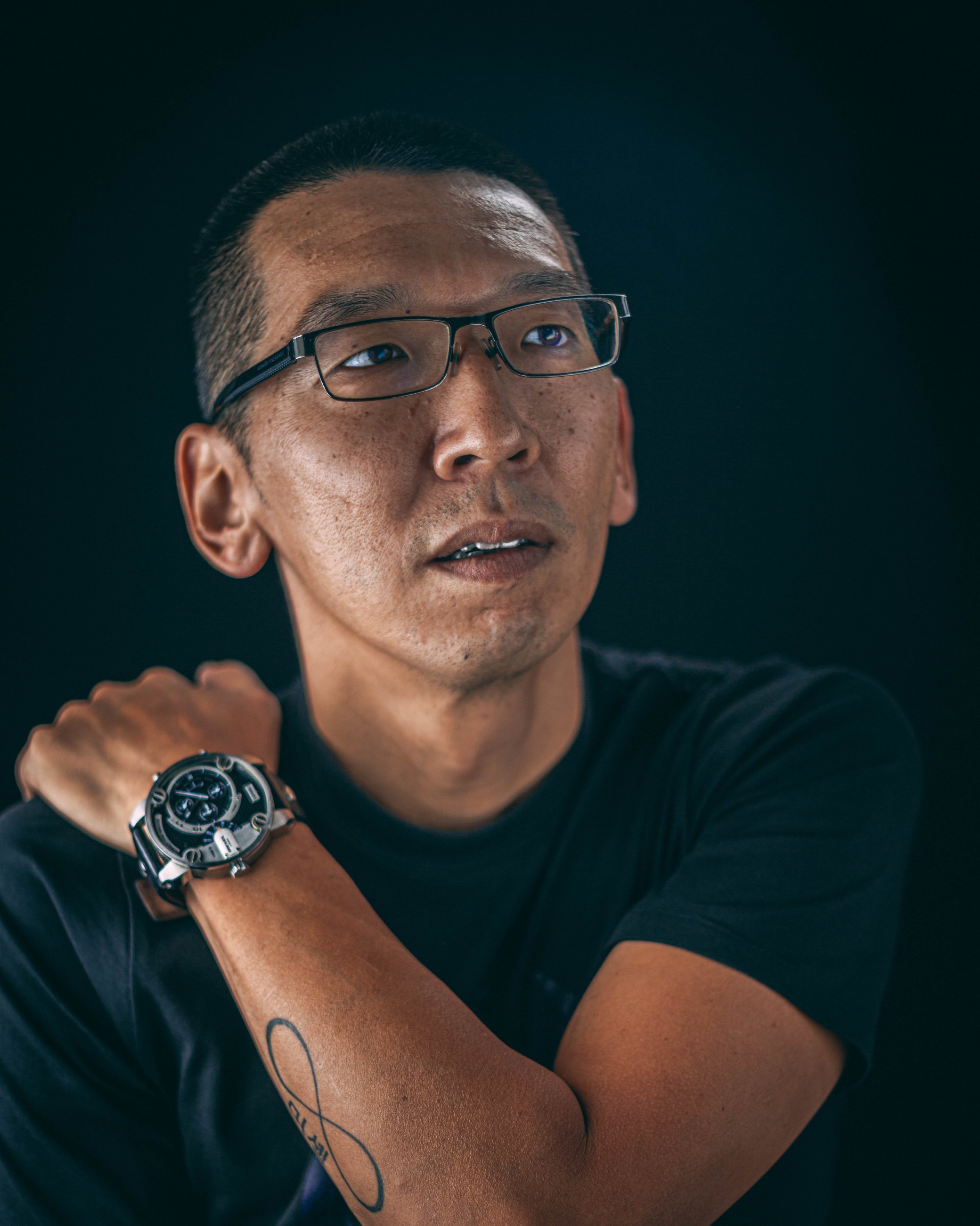 Studio portrait of a man with glasses looking upward, portrait photography by Everlux Photo Co.