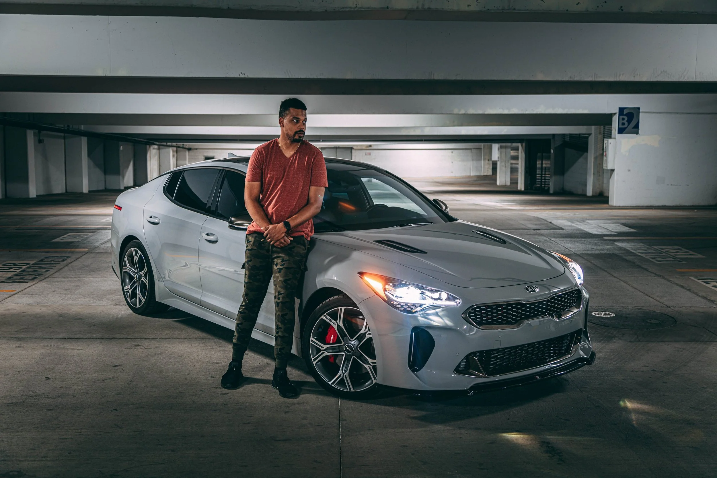 Portrait of a man posing with a white sports car in a parking garage, portrait photography by Everlux Photo Co.