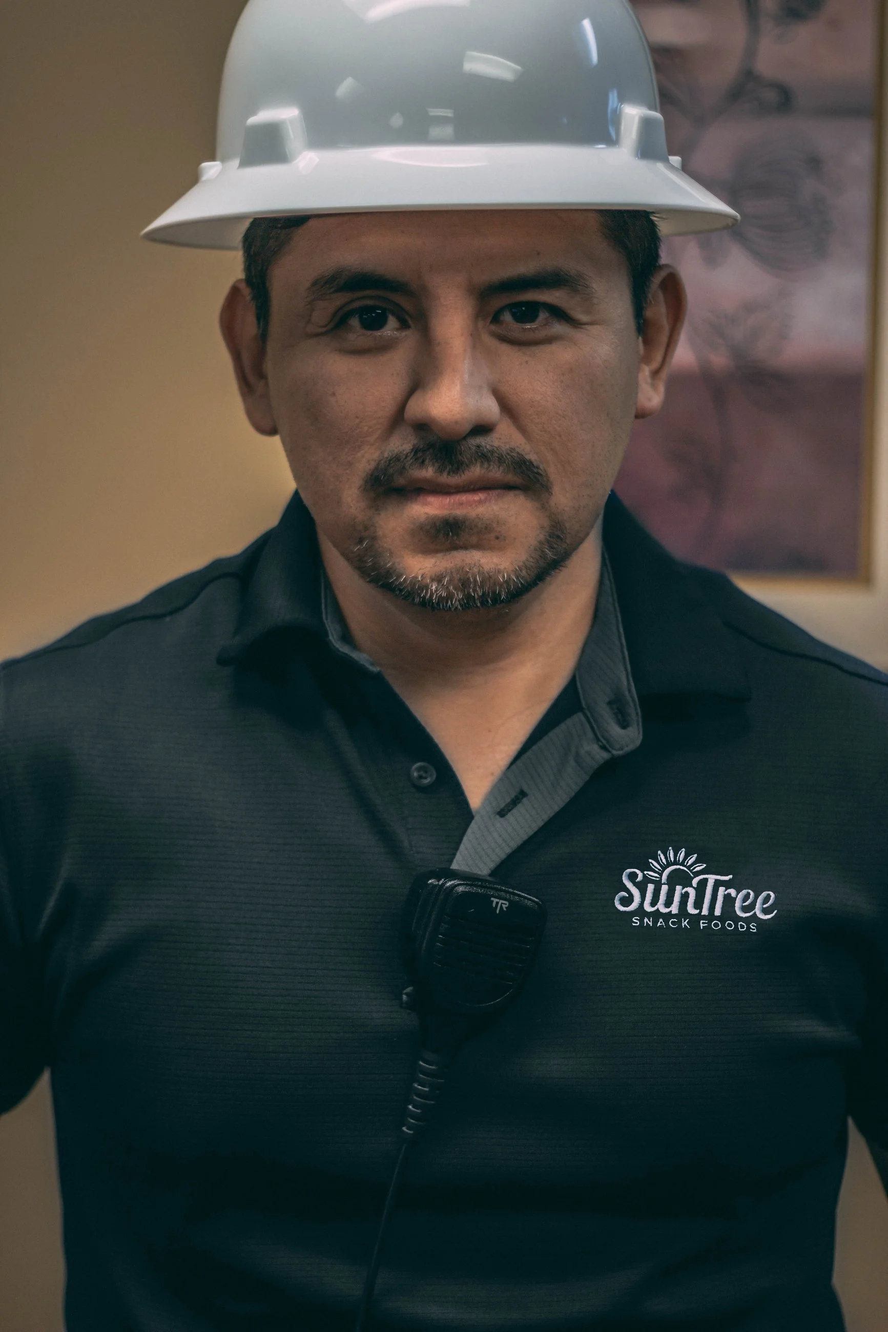 Professional headshot of a mustached man in a branded polo shirt, business headshot photography by Everlux Photo Co.