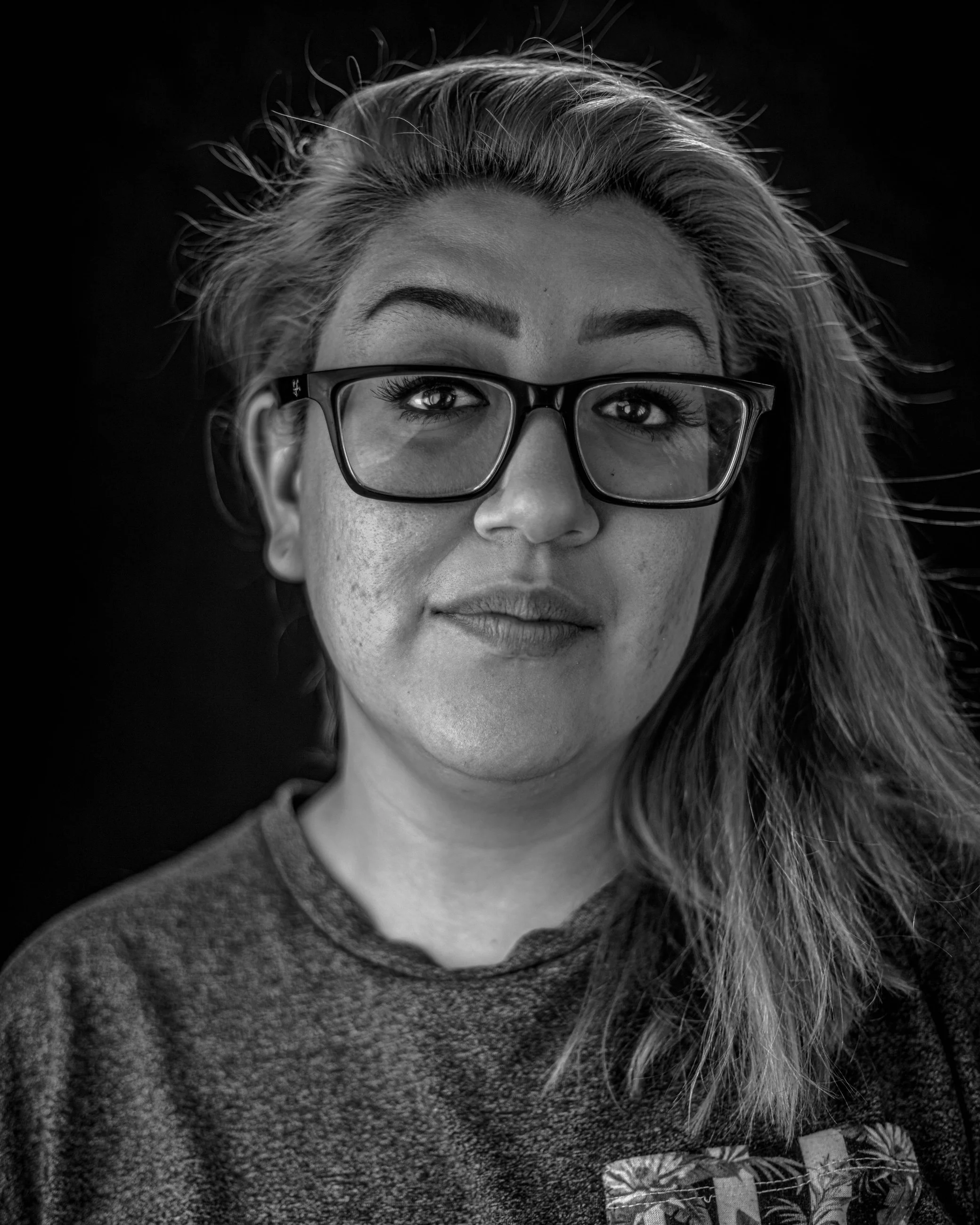 Black and white studio portrait of a woman with glasses, portrait photography by Everlux Photo Co.