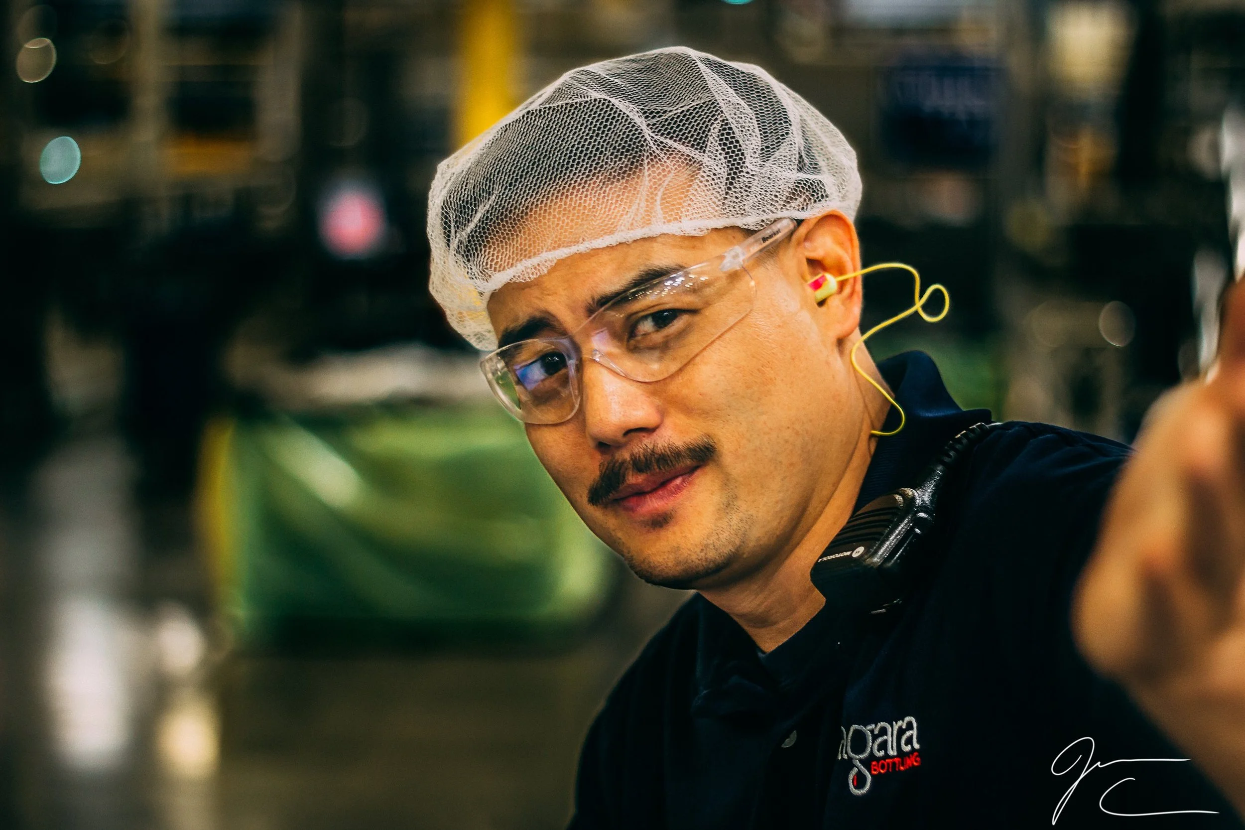 Corporate headshot of a man wearing a hairnet in an industrial facility, commercial headshot photography by Everlux Photo Co.