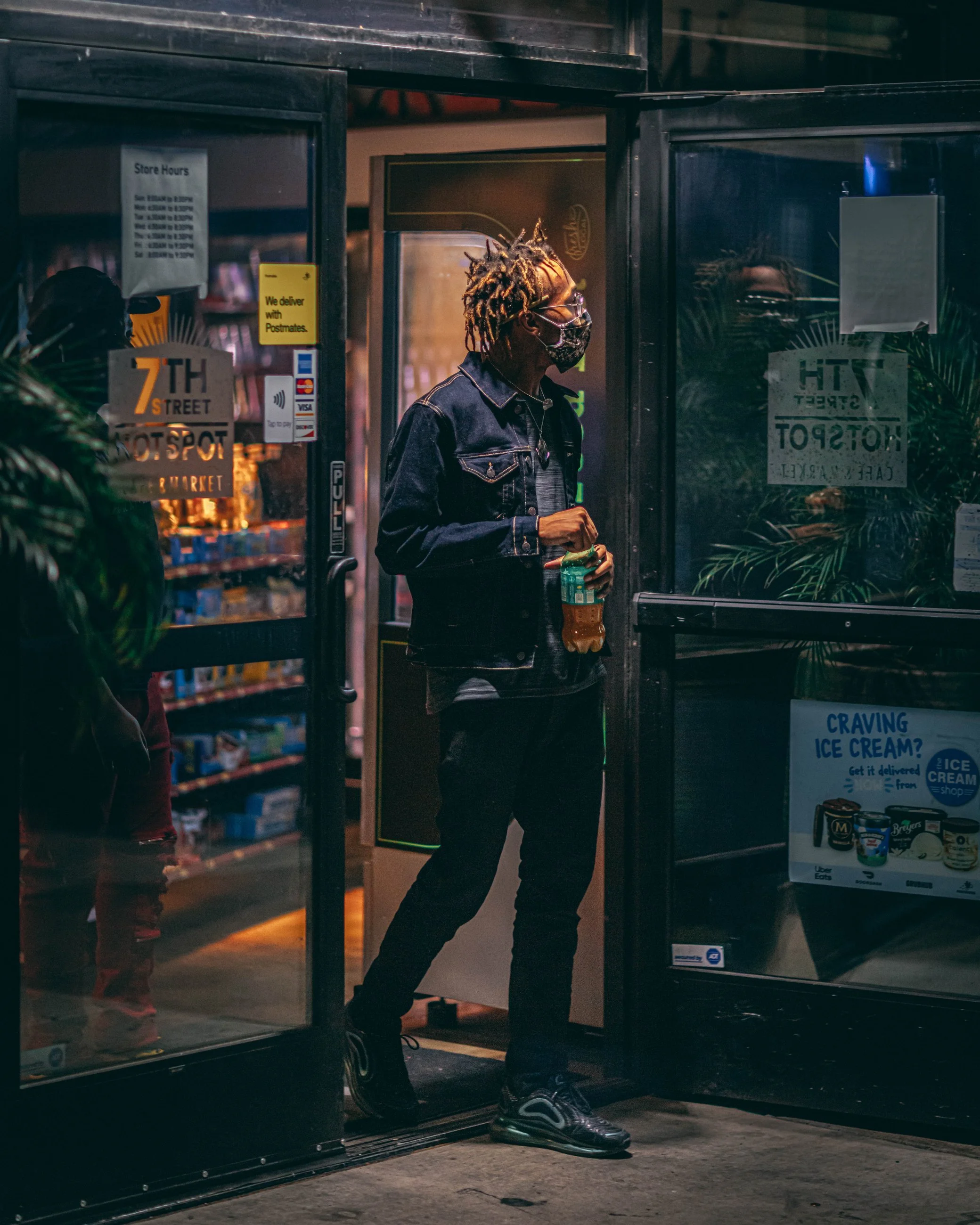 Candid nighttime portrait of a man exiting a convenience store, urban portrait photography by Everlux Photo Co.