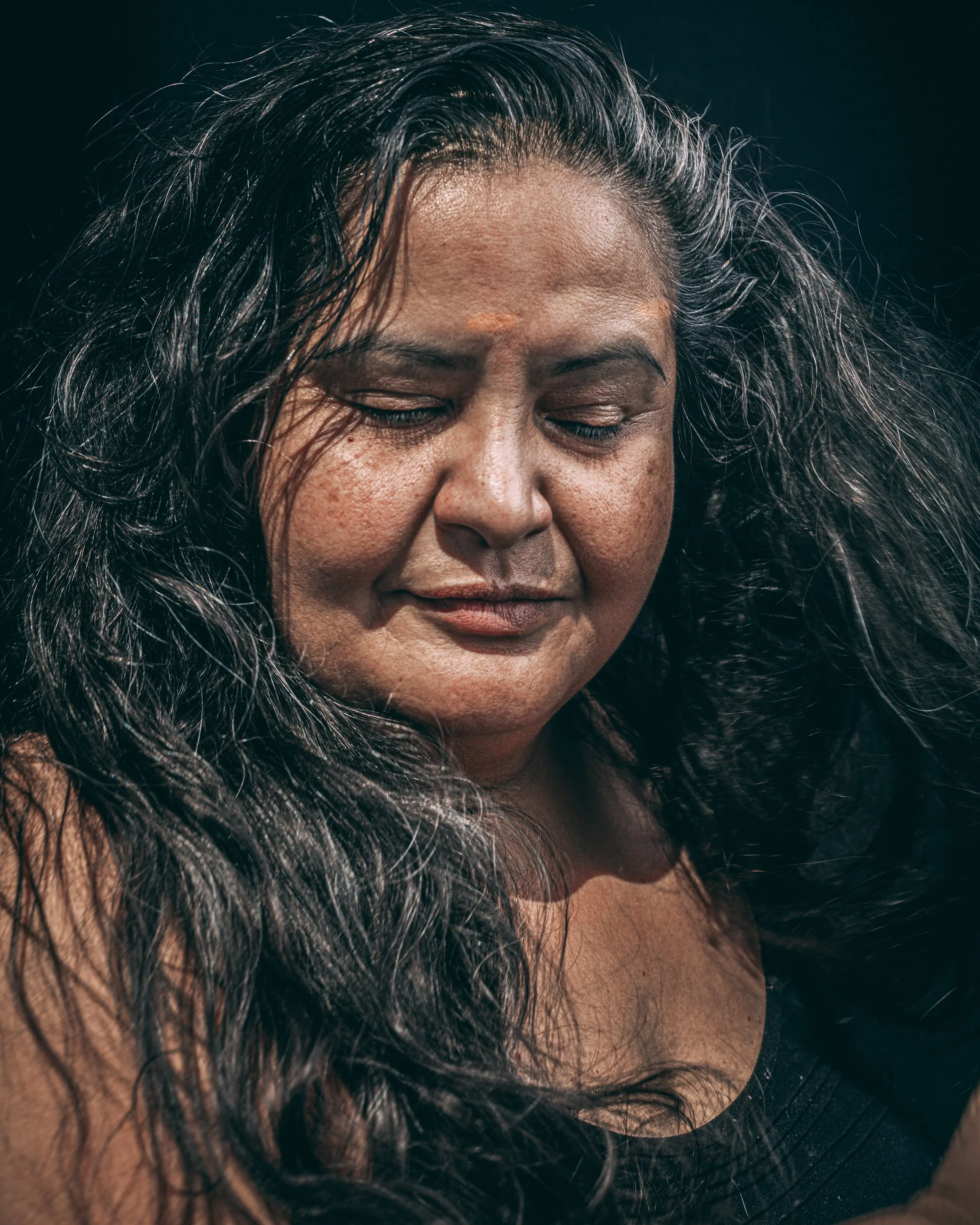 Artistic portrait of a woman with flowing dark hair and closed eyes, portrait photography by Everlux Photo Co.