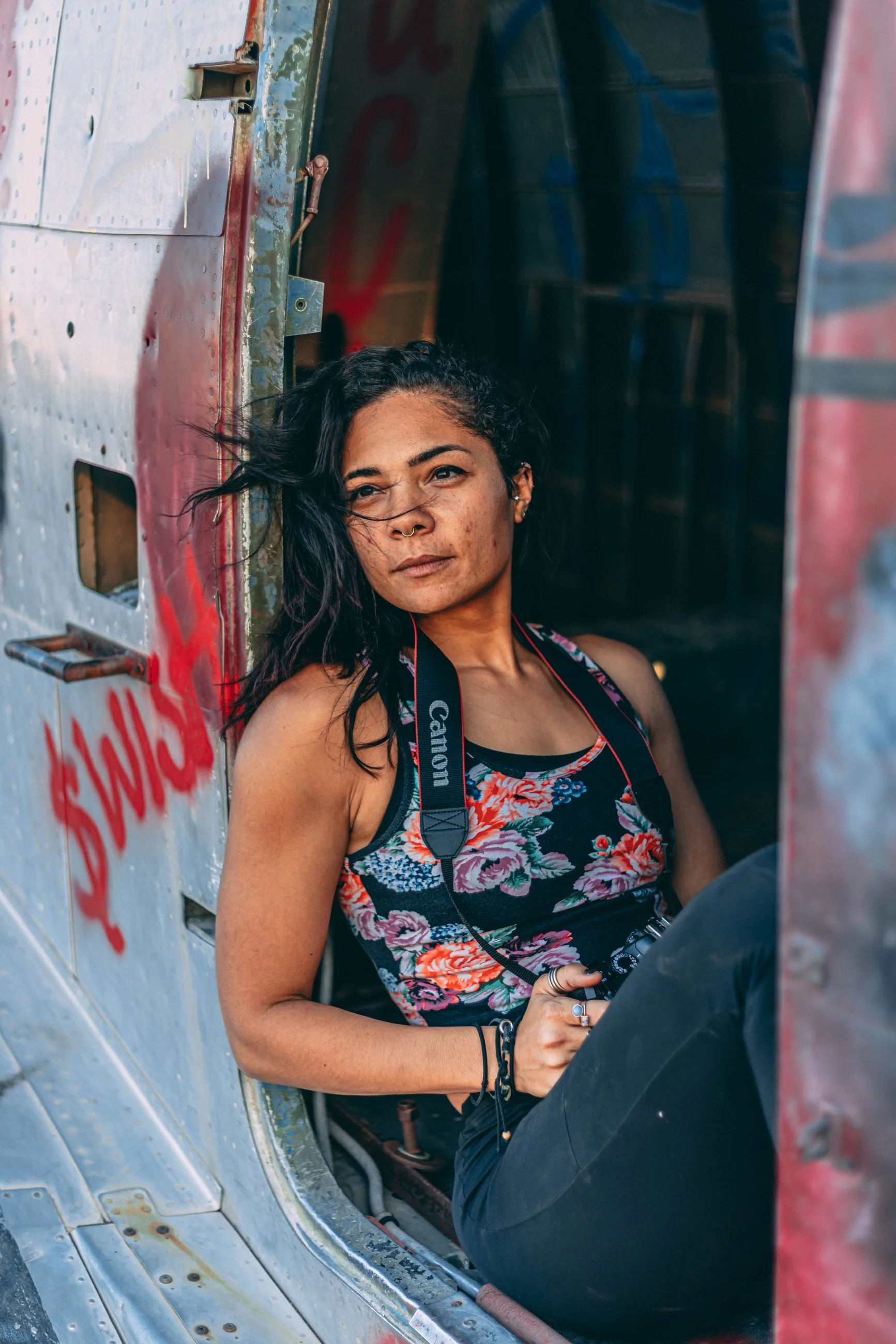 Portrait of a woman in a floral top against an urban graffiti wall, portrait photography by Everlux Photo Co.