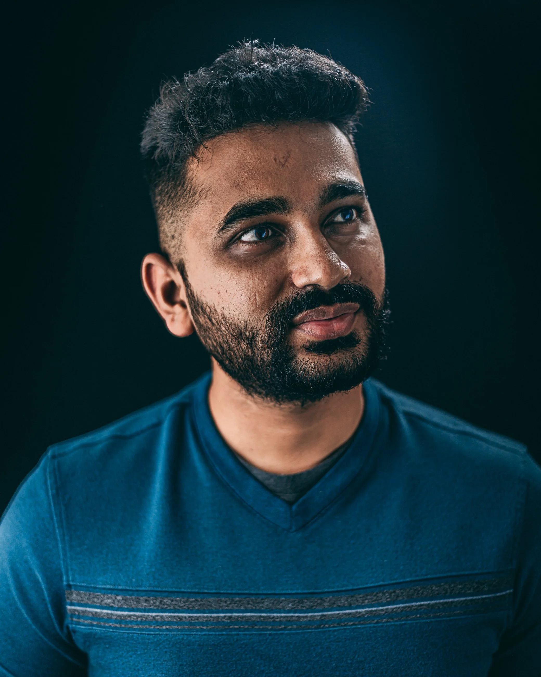 Studio portrait of a man with a beard wearing a teal sweater, portrait photography by Everlux Photo Co.