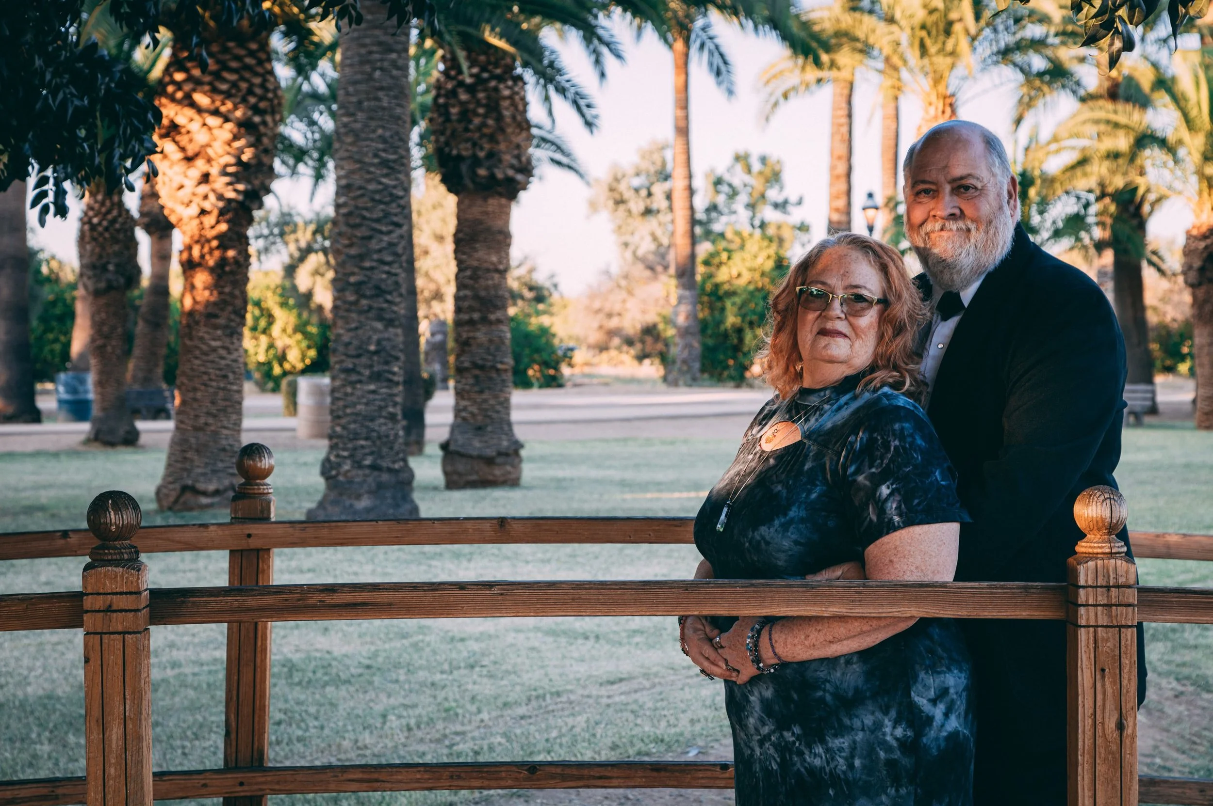 Portrait of a couple standing together under palm trees at golden hour, portrait photography by Everlux Photo Co.