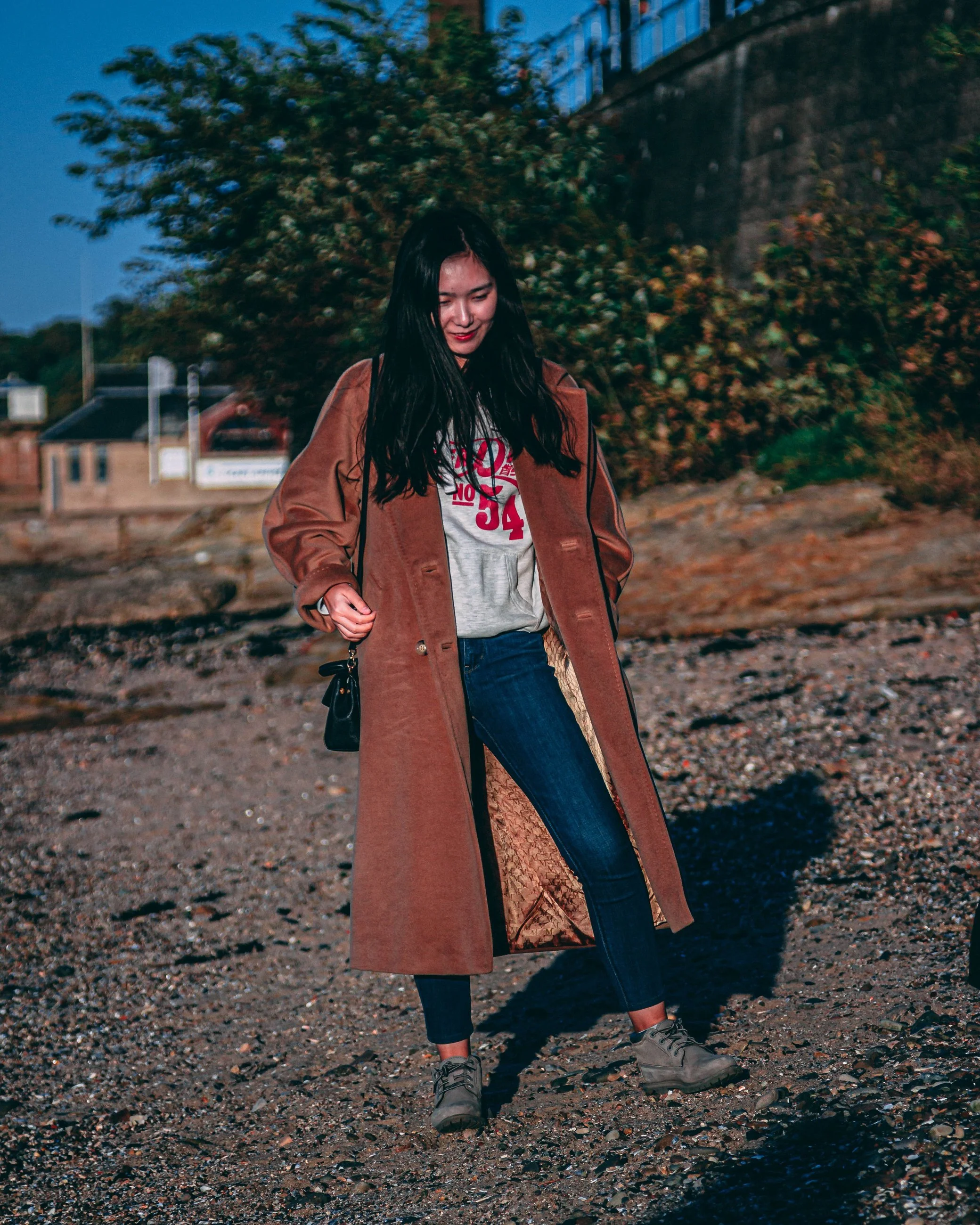 Full-body editorial portrait of a woman in a brown trench coat walking outdoors, portrait photography by Everlux Photo Co.