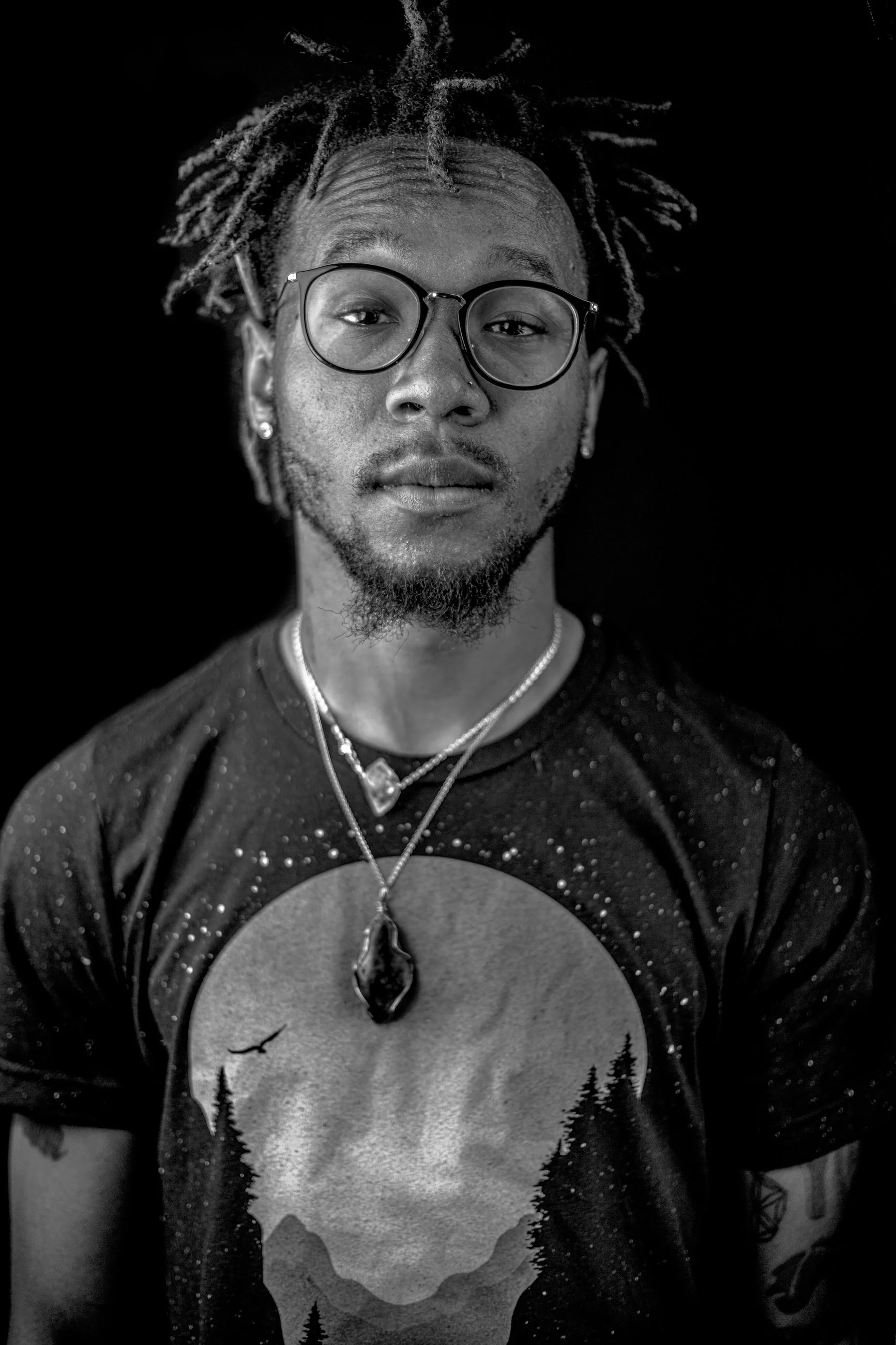 Black and white portrait of a man in a graphic t-shirt, portrait photography by Everlux Photo Co.