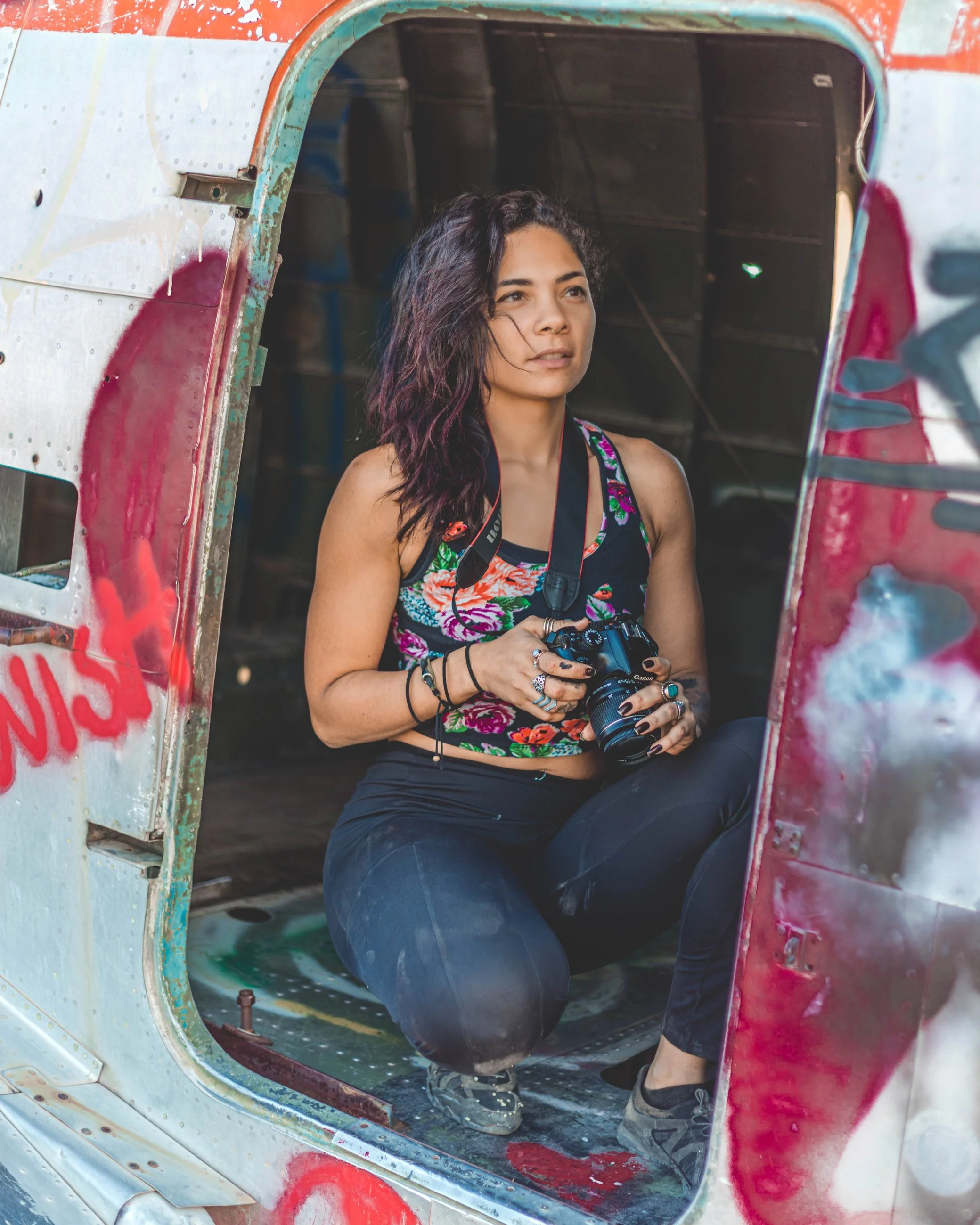 Portrait of a woman seated in a graffiti-covered doorway, urban portrait photography by Everlux Photo Co.