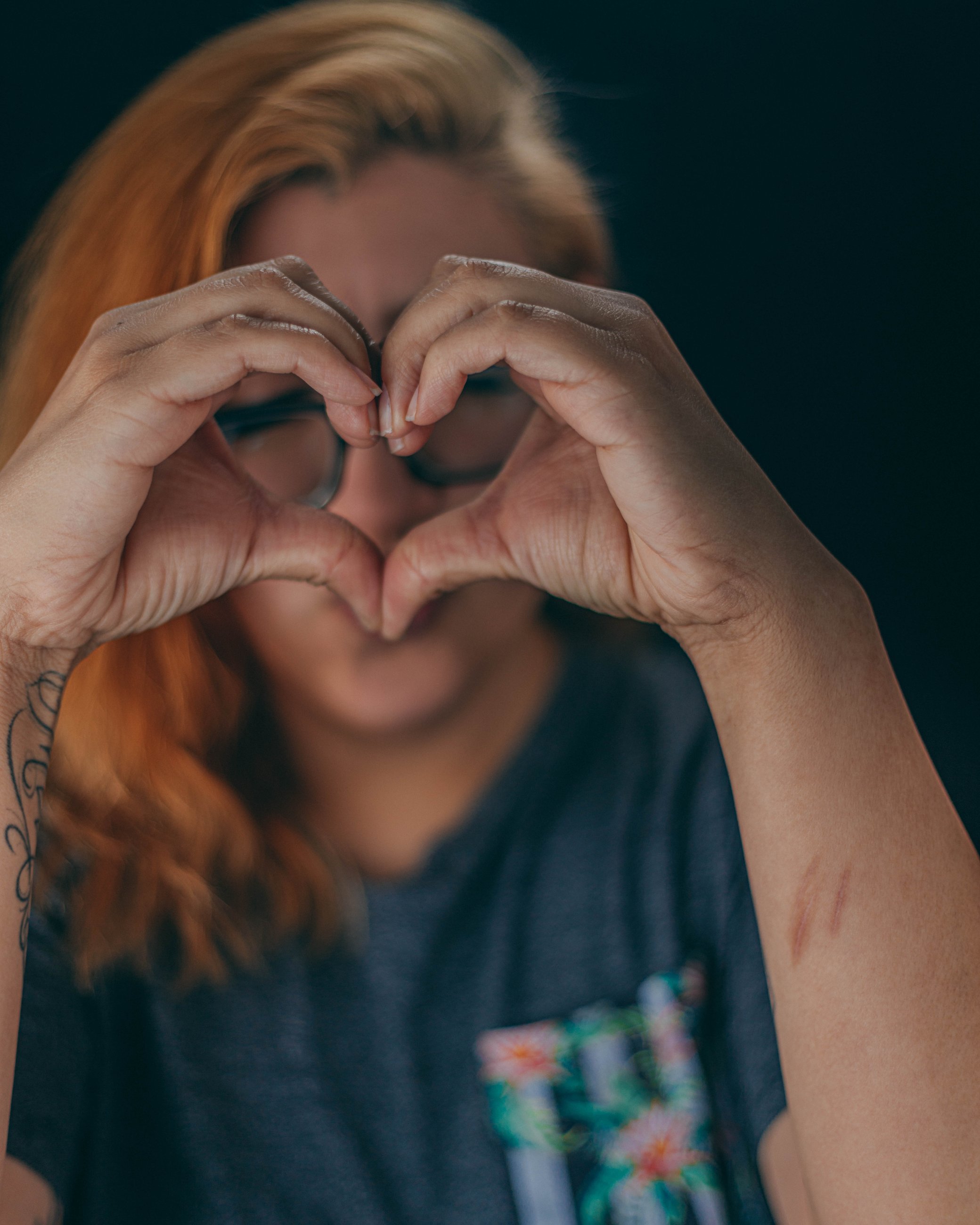 Studio portrait of a woman forming a heart shape with her hands, portrait photography by Everlux Photo Co.