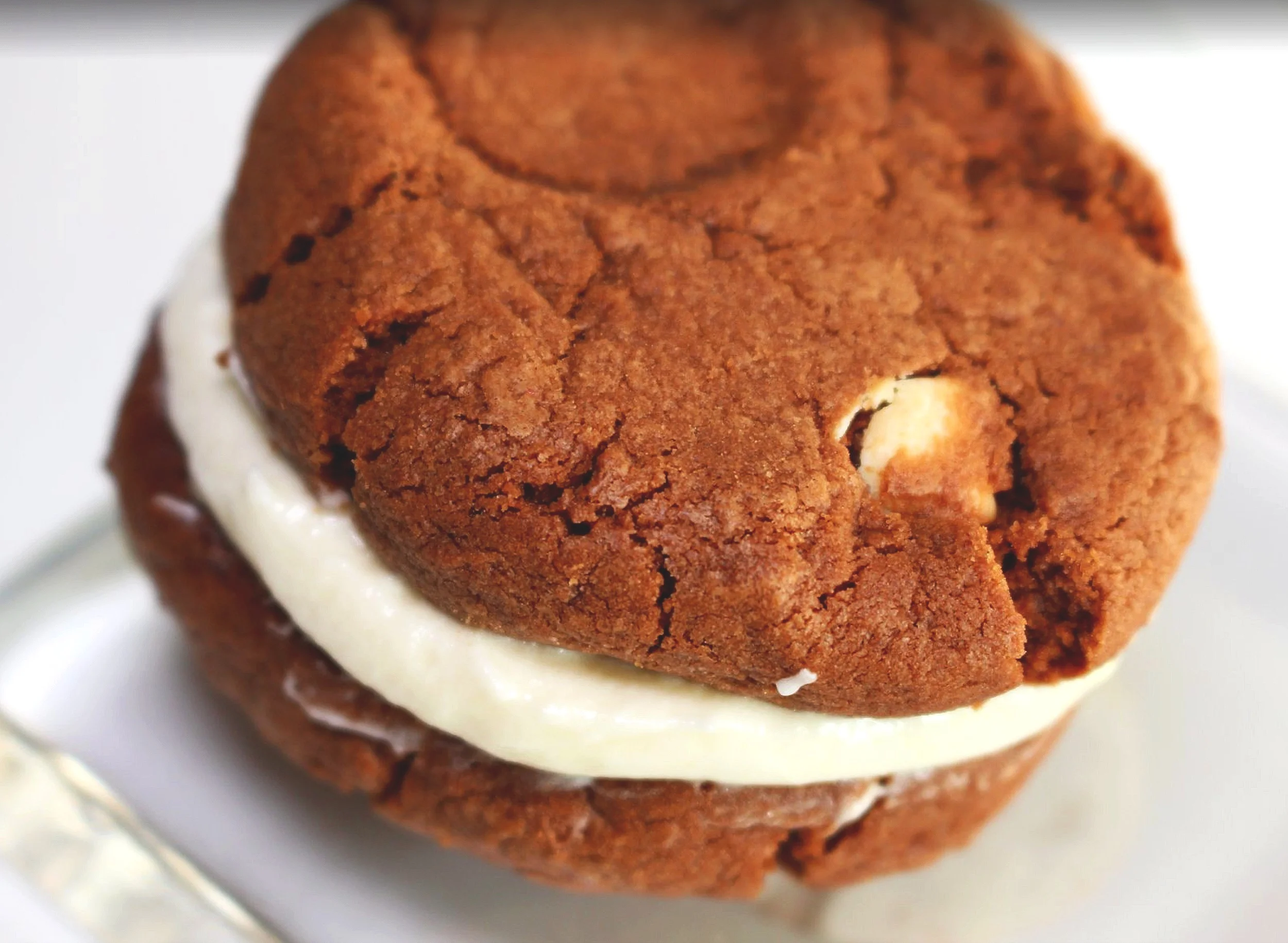 Double chocolate chip sandwich cookie, with a whipped cream cheese butter frosting!