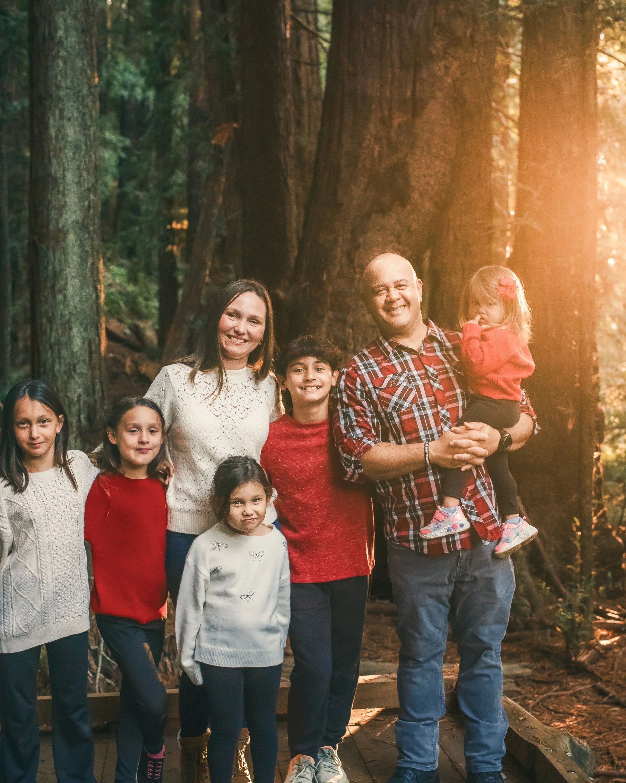 Large family photographed among the redwood trees during a family photo session in Marin County.