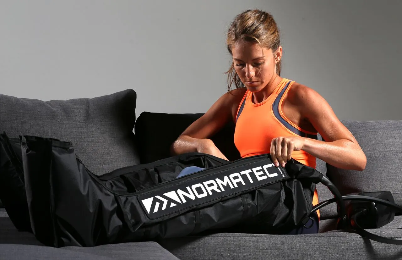A woman using a compression therapy sleeve on her legs