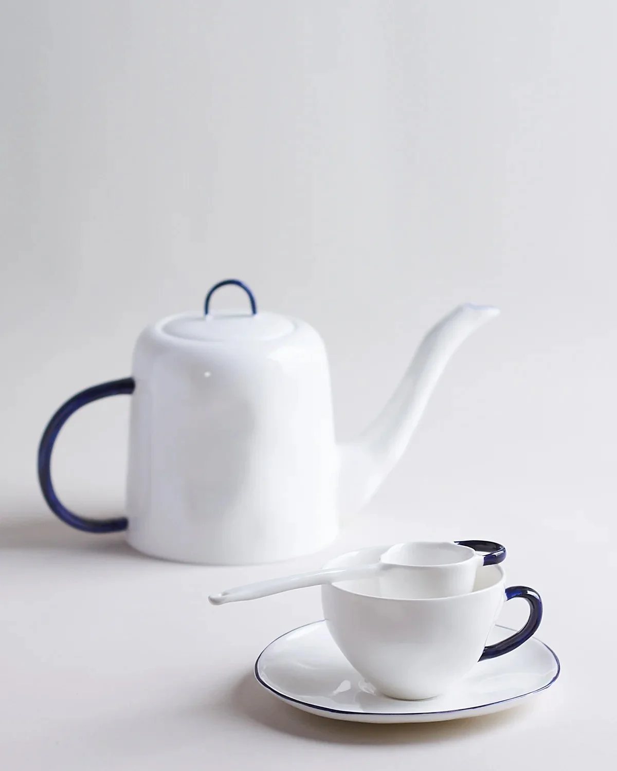 Tea cup and saucer with tea pot.jpg