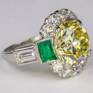 A Fancy Yellow Diamond, Emerald and Platinum Ring sold for $55,000