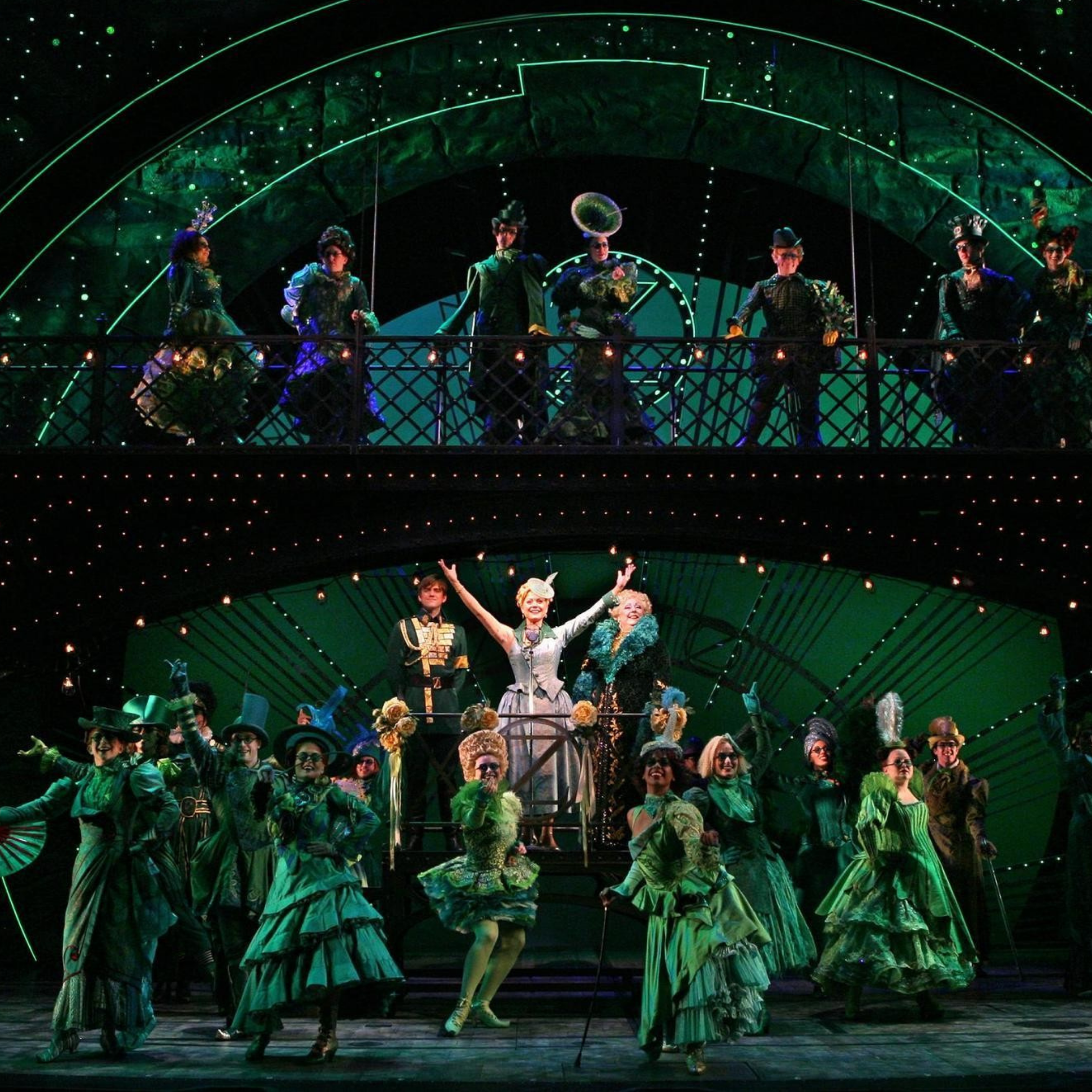 WICKED cast members performing a musical number on stage.