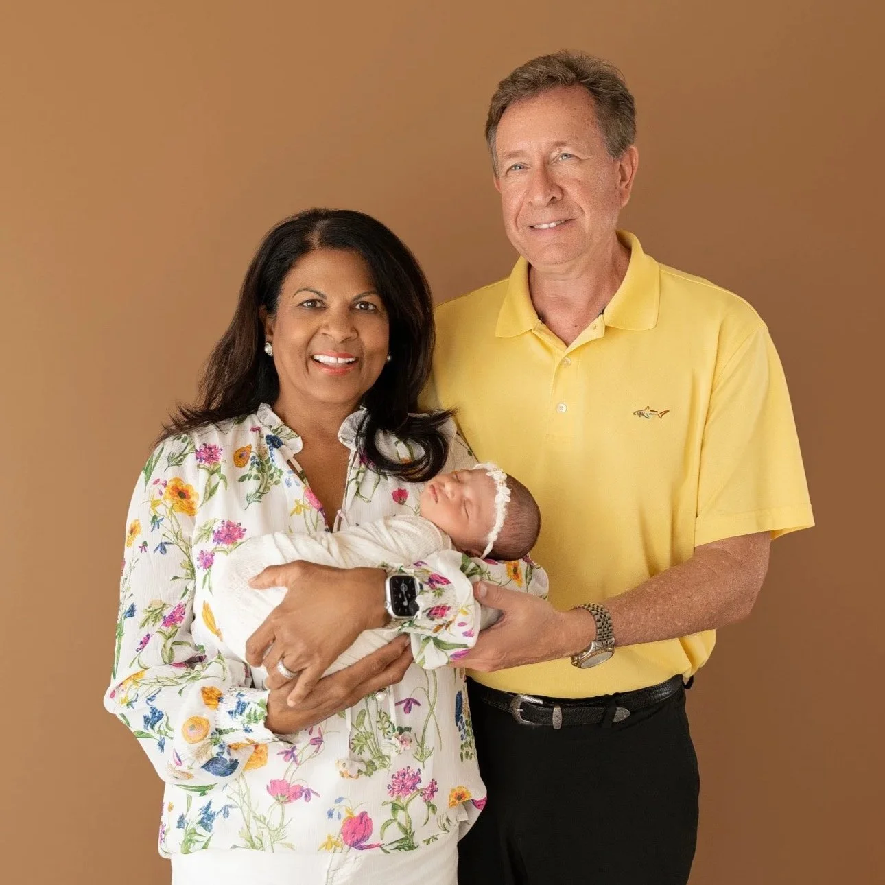 Grandmother and grandfather holding baby Olivia in the Cypress photo studio.