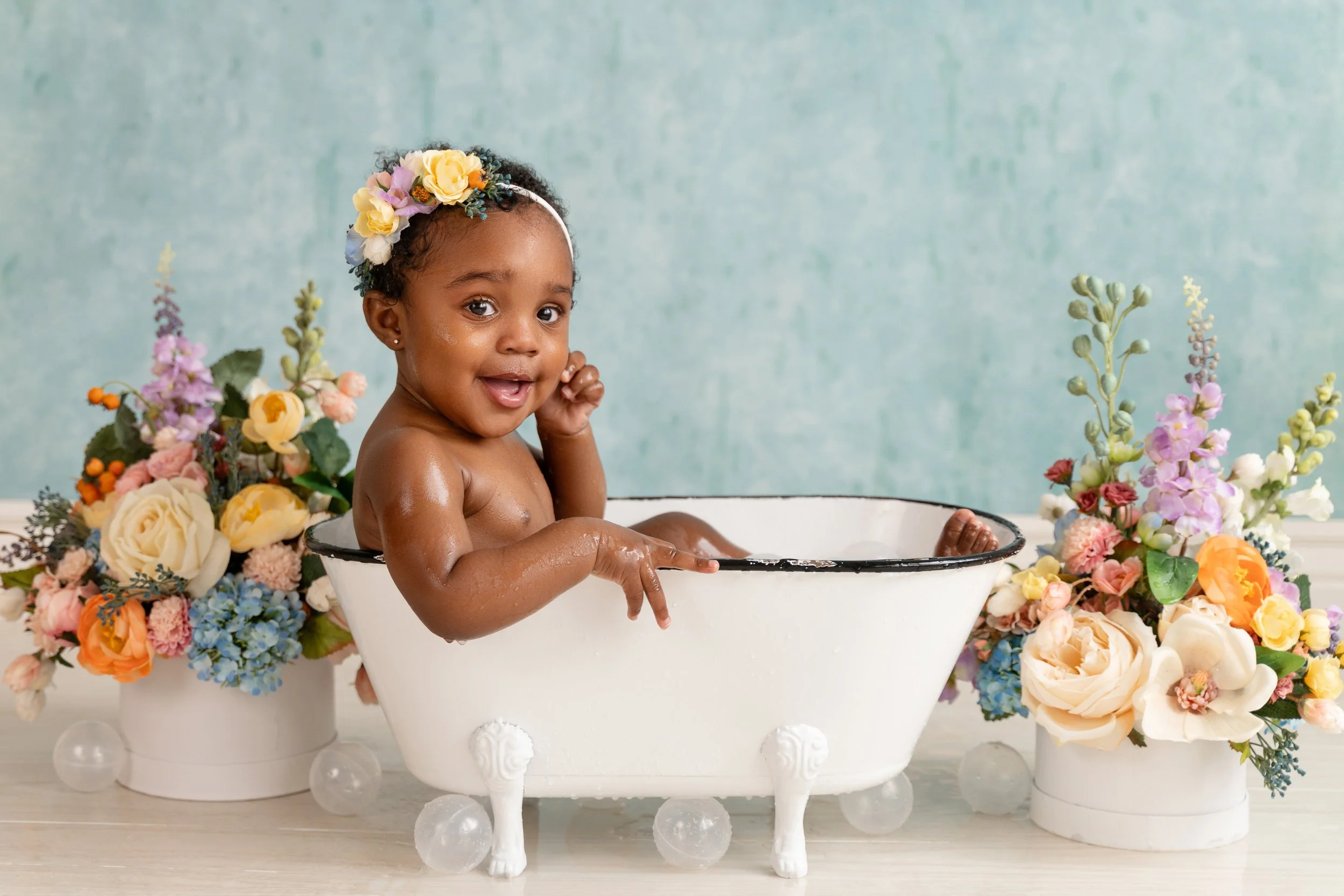 Baby girl celebrating her first birthday with a bubble bath