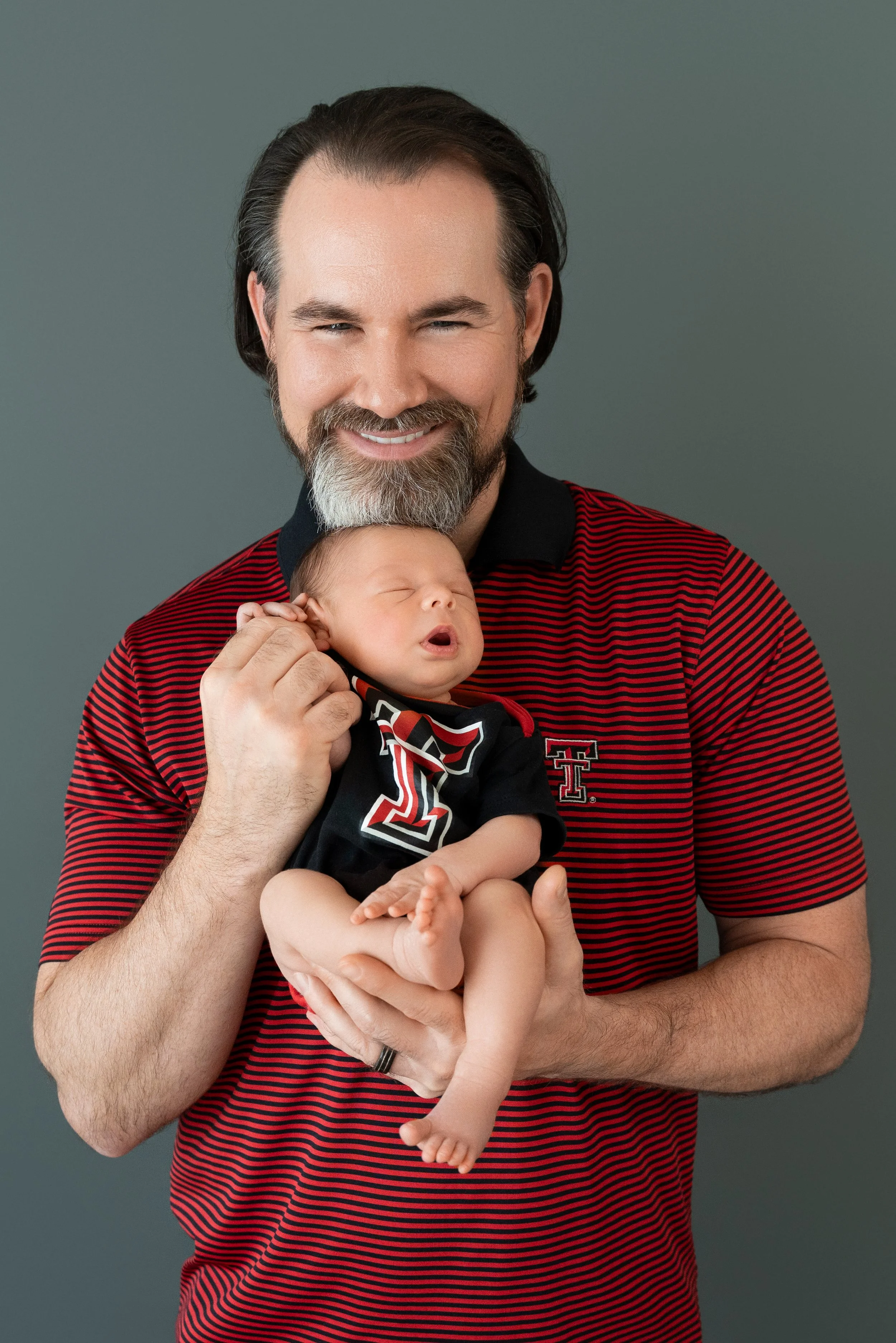 Dad and baby Archer in matching Texas Tech outfits during a studio newborn session.