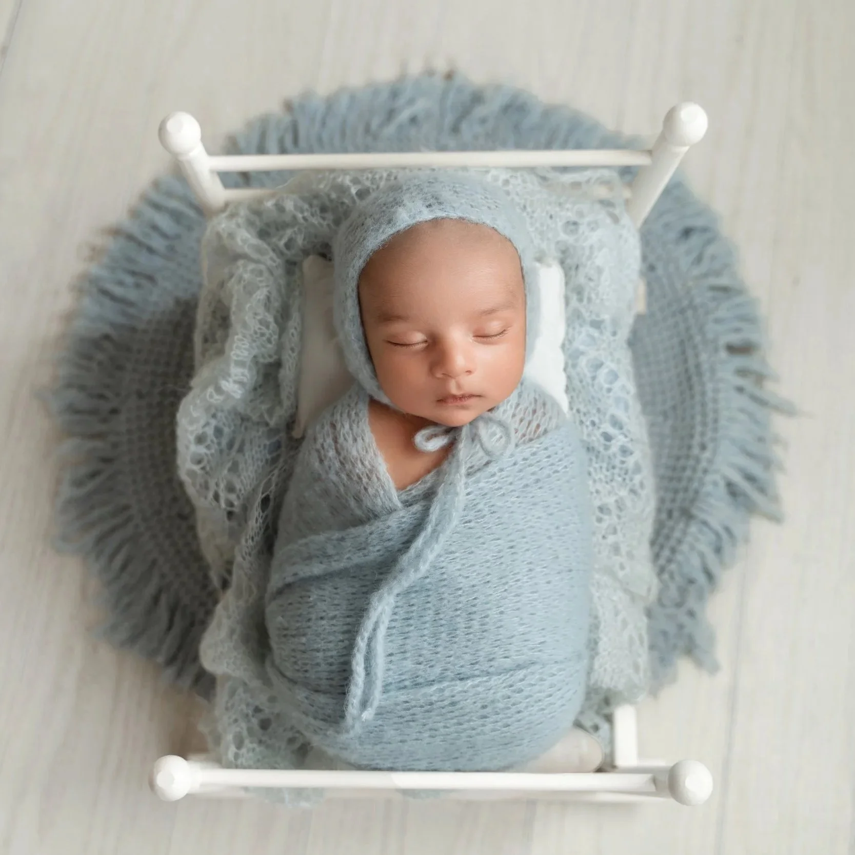 Sleeping newborn baby boy posed in a wooden prop during a simple newborn photography session
