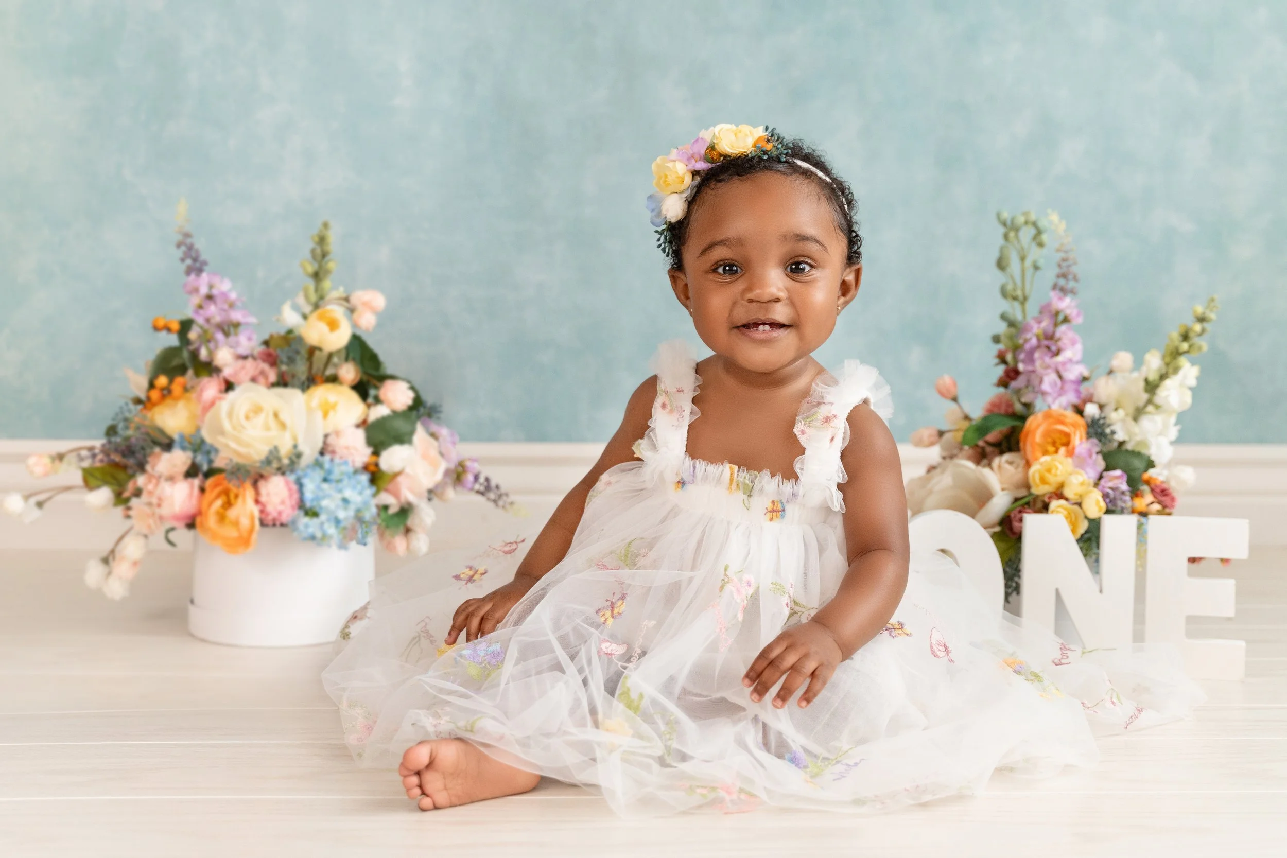 Handmade floral headband and cake decorations created by mom for Ava’s one-year session.