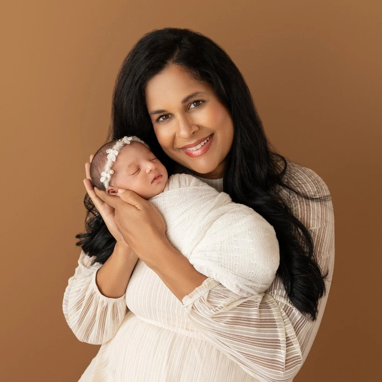 Tender moment between mom and newborn Olivia during a studio newborn session.