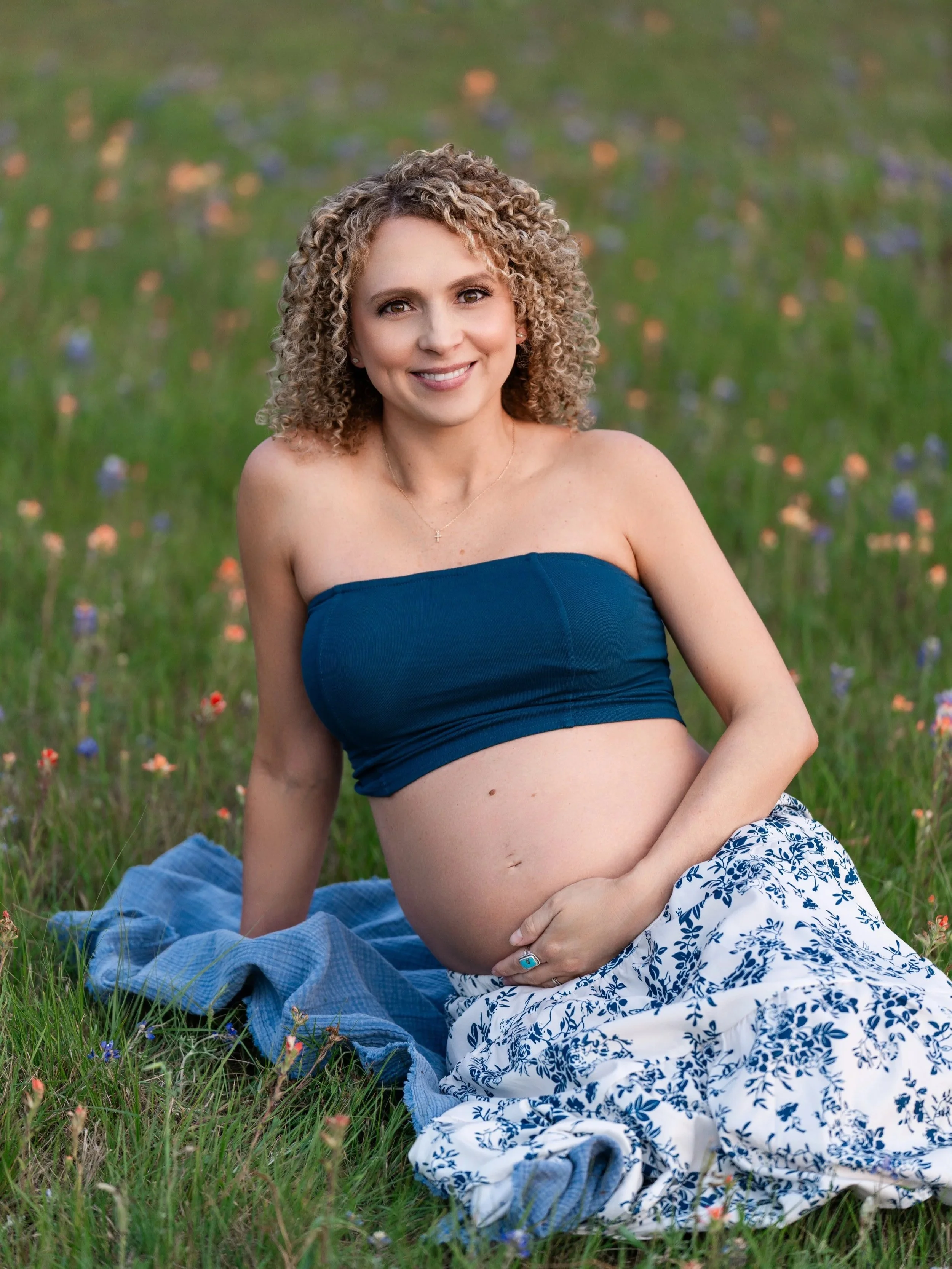 mom posing in a field of bluebonnets near Cypress TX
