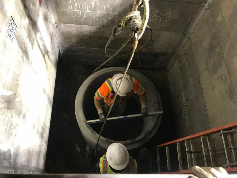 MCTC workers coordinate with Paradigm Mechanical to install a sump pit at the base of an elevator shaft.