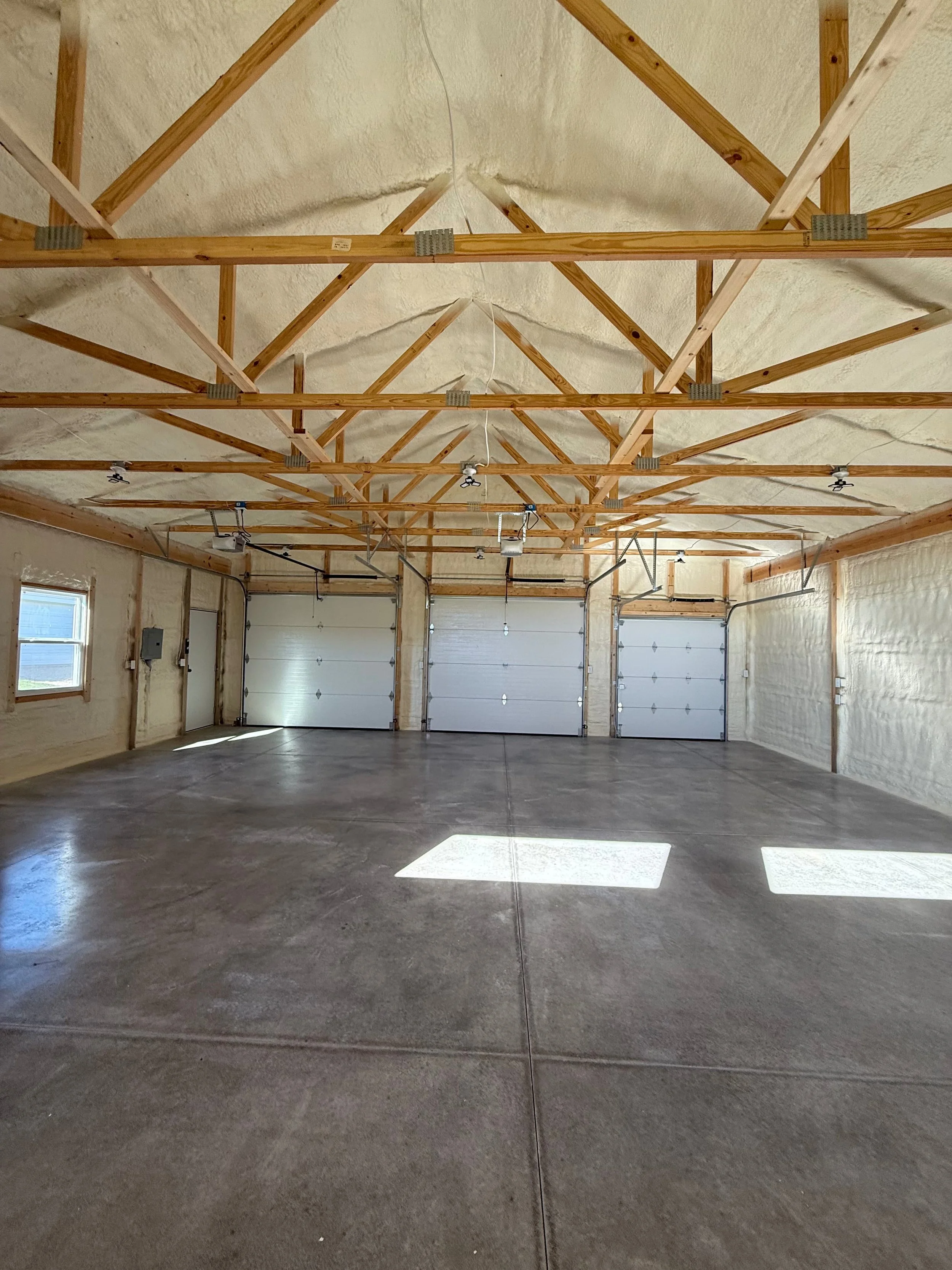 completed spray foam insulation covering ceiling trusses and walls of a multi-bay residential garage — Summit Sprayfoam, Ohio