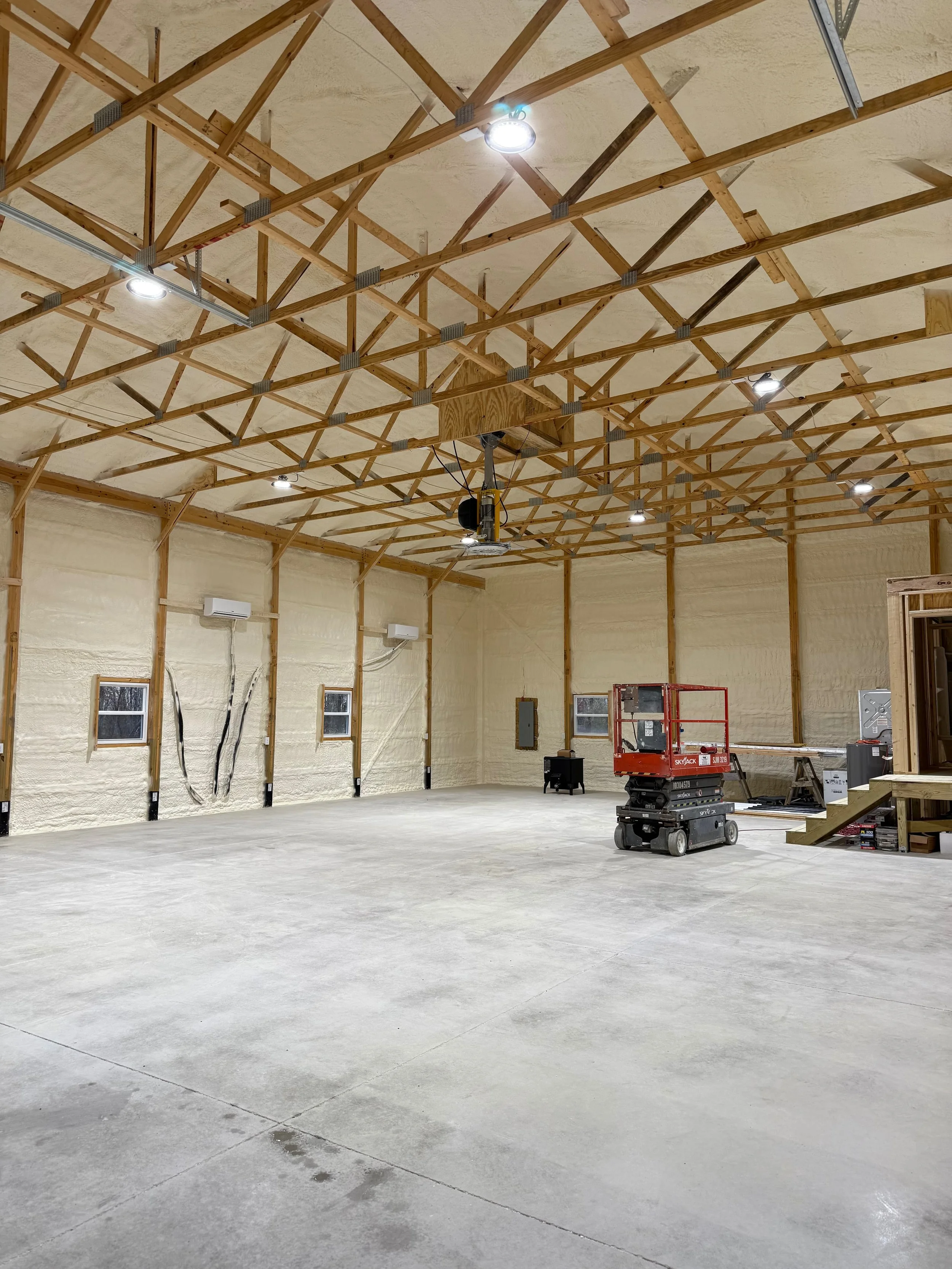 spray foam insulation applied to all interior walls and roof trusses of a commercial workshop with auto lift — Summit Sprayfoam, Ohio