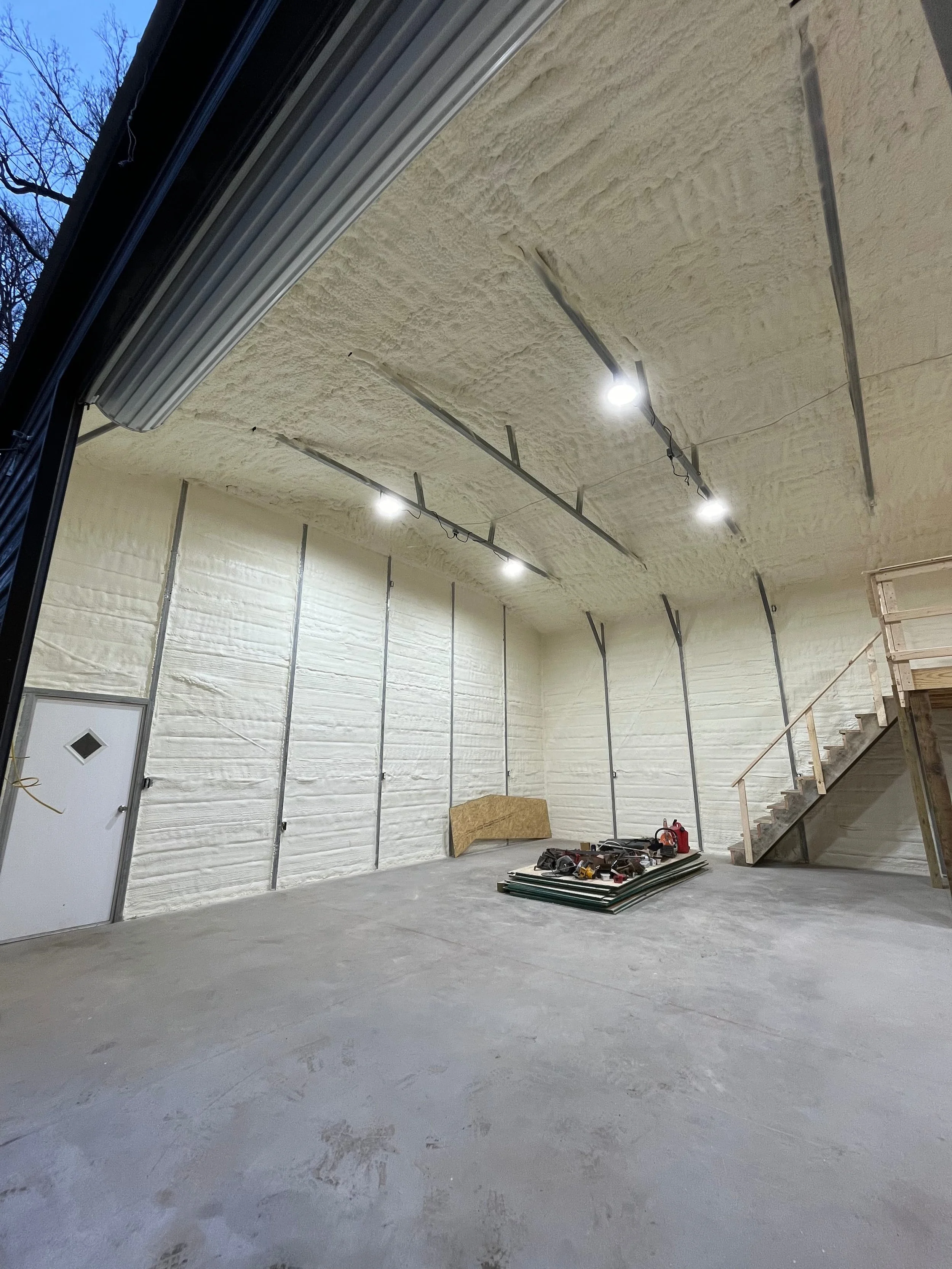 spray foam insulation applied to curved ceiling and walls of a metal building under construction — Summit Sprayfoam, central Ohio
