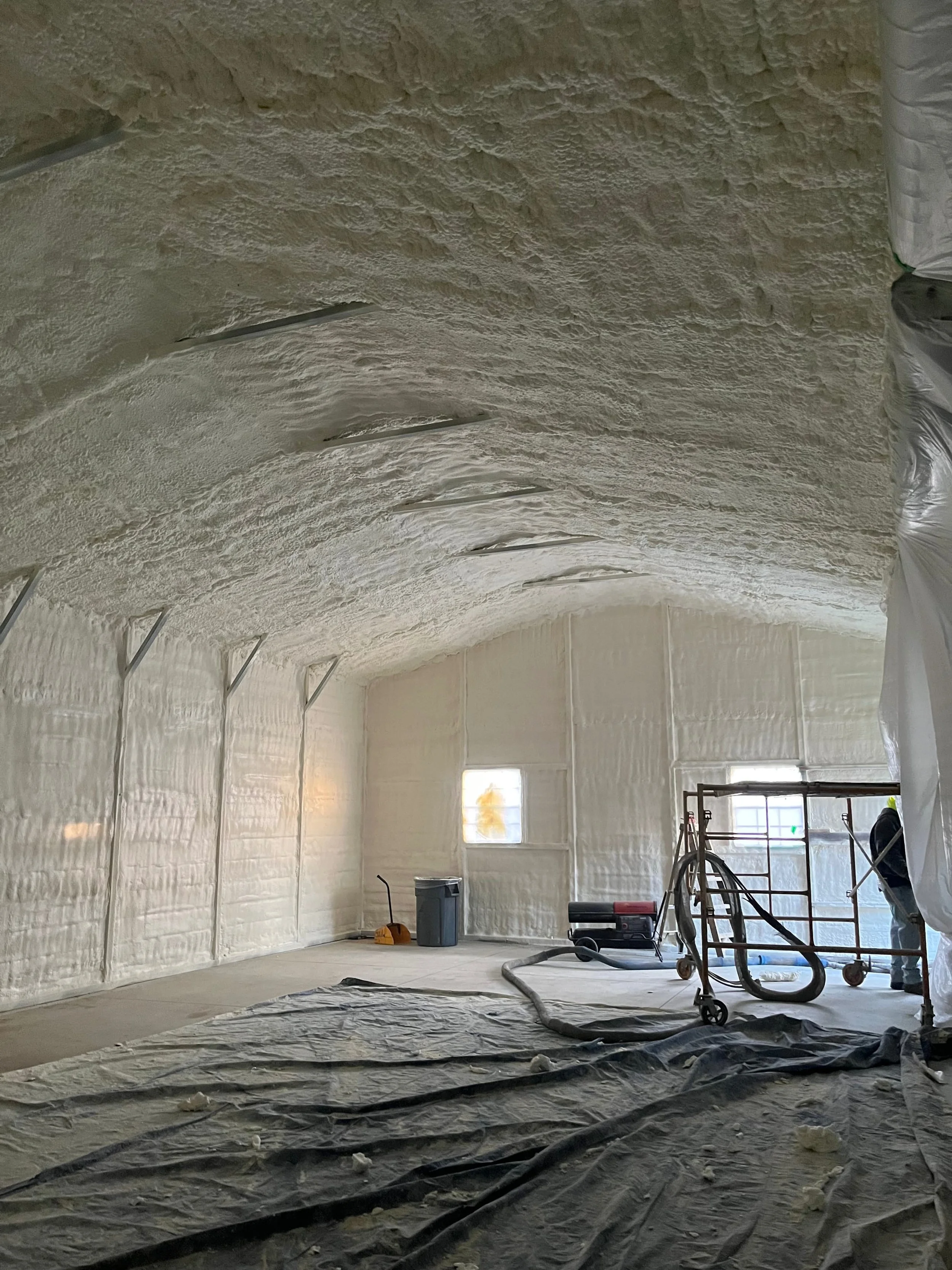 close-up of spray foam insulation covering roof trusses and decking of a large residential or commercial garage — Summit Sprayfoam, Ohio