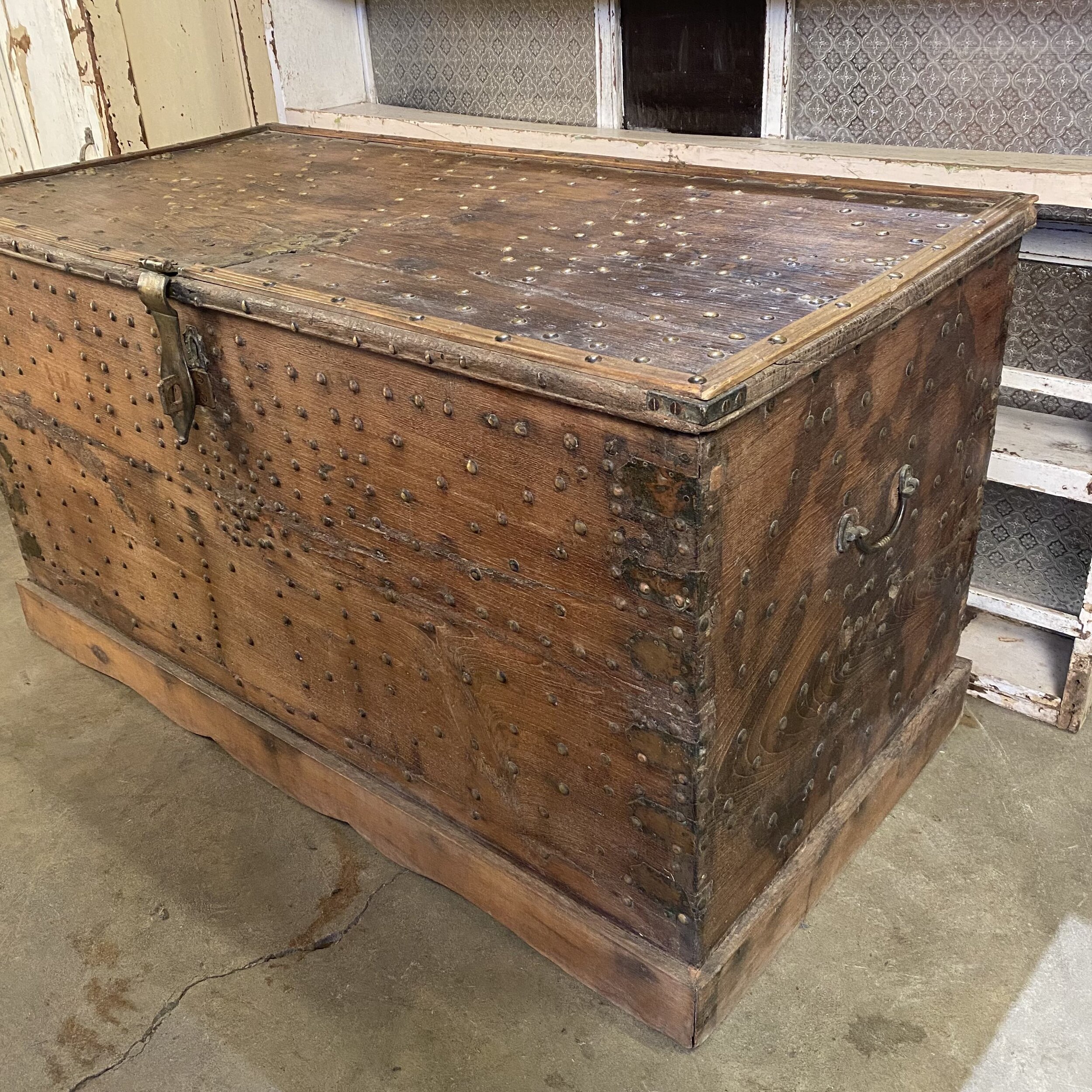 Large wooden chest with brass details, partial side view