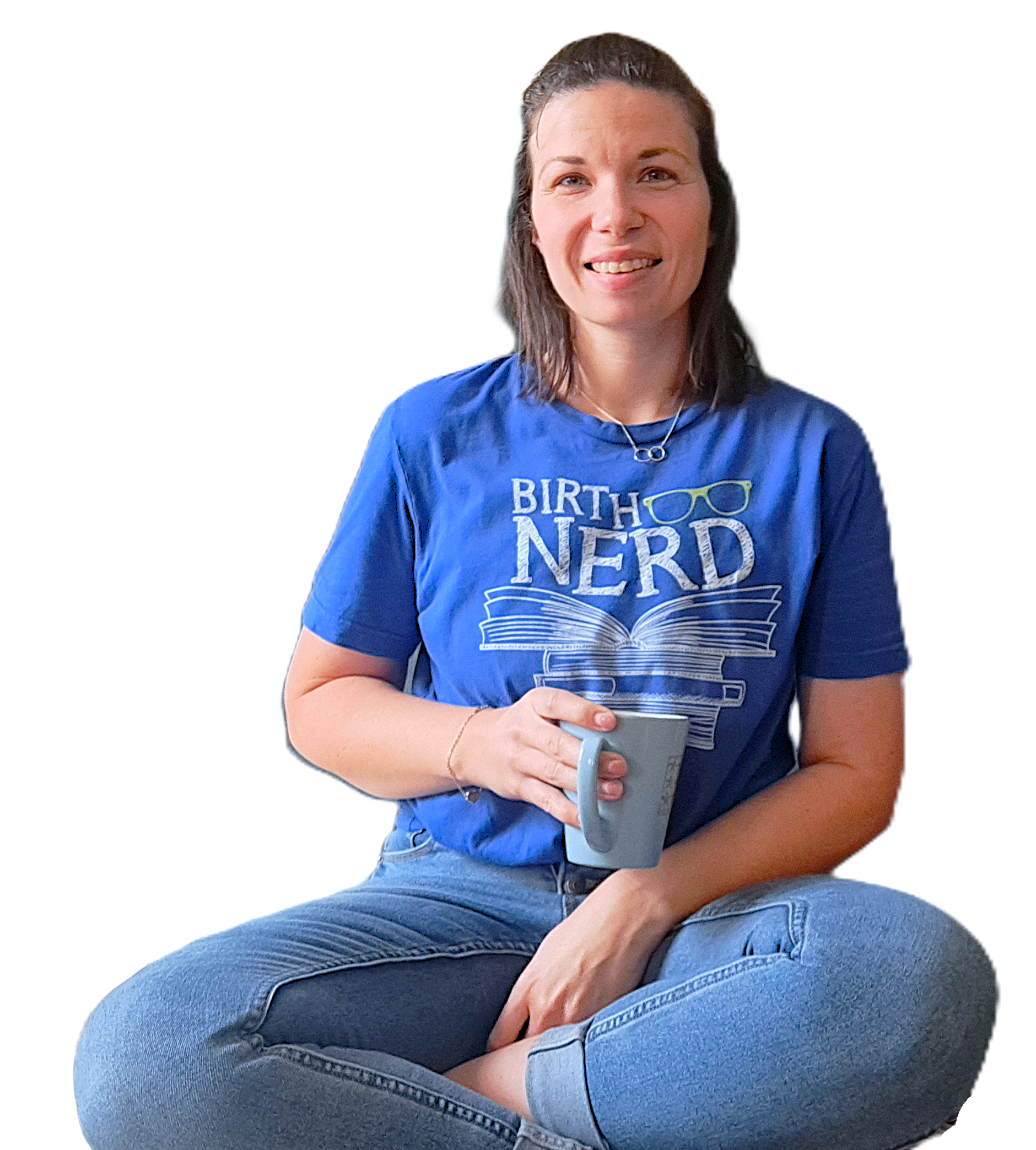 A woman sitting cross-legged, holding a mug, wearing a blue t-shirt with the words 'BIRTH NERD' and an illustration of books and glasses on it, smiling at the camera.