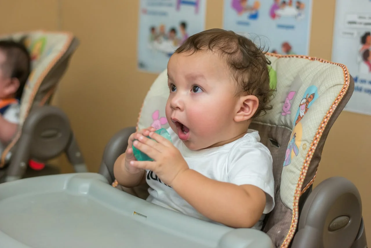 Baby holding an open cup