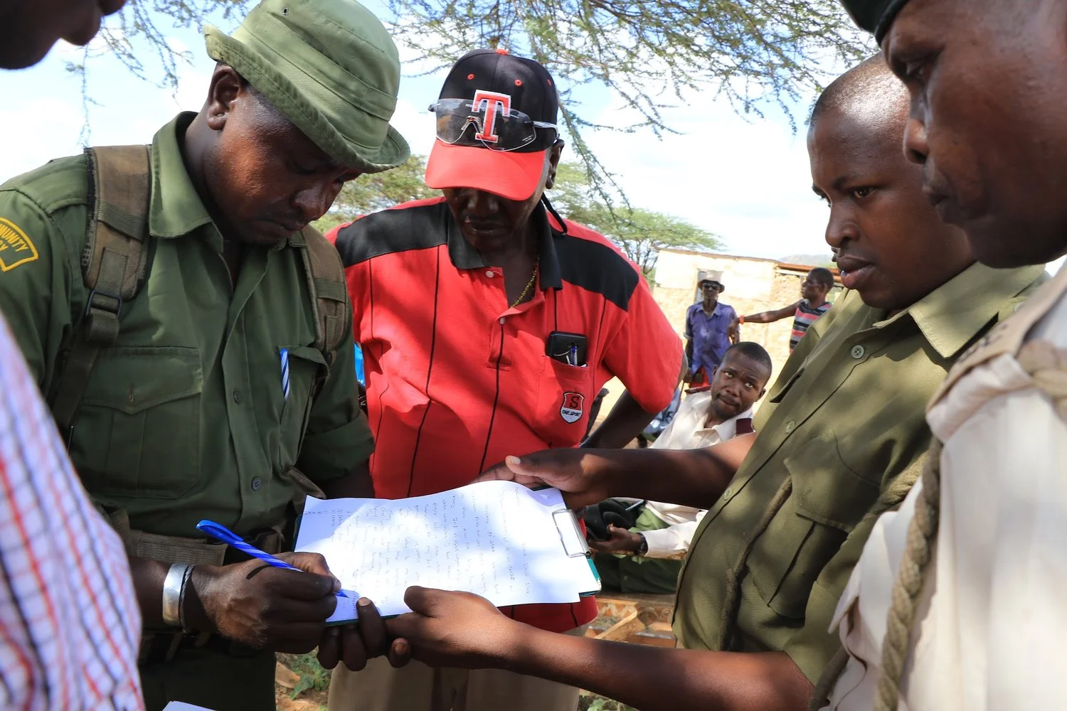 Diwani Parkusaa signs confirmation of receipt, witnessed by Waso Wwest chief, Kaward Lekalkuli, and Archers Post OCS Simon Gitau.