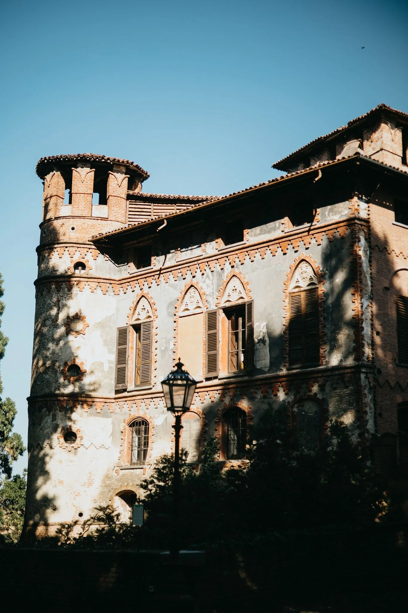 La torre in mattoni del Castello di Piovera si staglia contro il cielo azzurro.