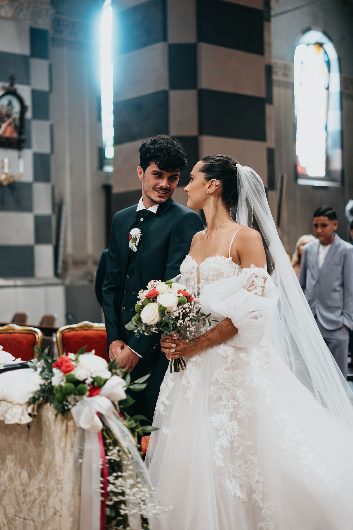 sguardo complice tra gli sposi all'altare in chiesa ad Alessandria, durante la cerimonia
