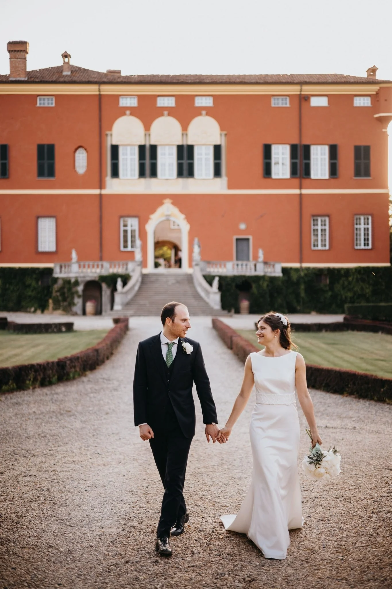 beatrice-giorgio-sposi-camminano-in-giardino-castello-di-pasturana.jpg