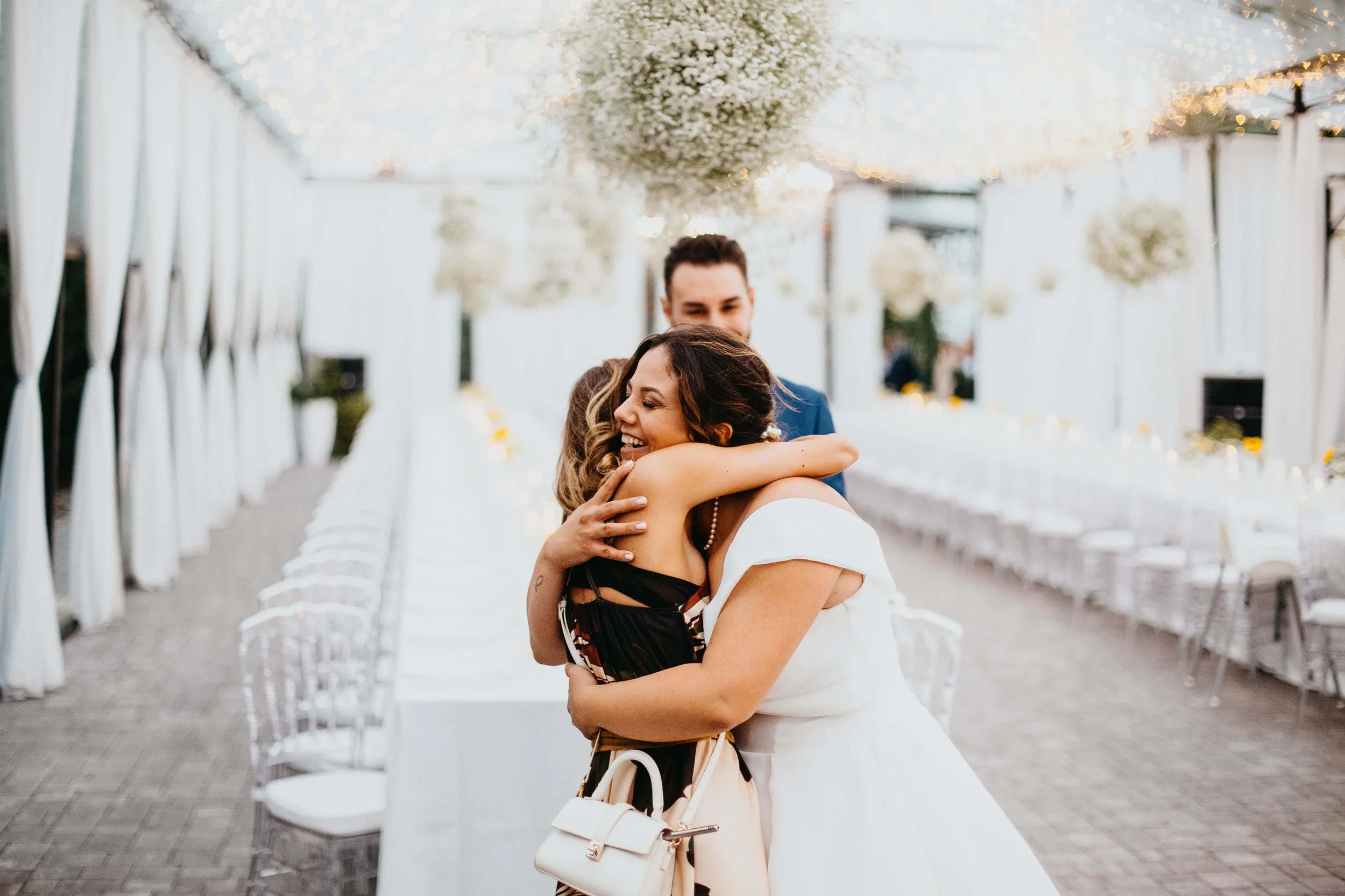 Una sposa abbraccia la wedding planner Eloisa Massolo nella serra dei Giardini La Pergola