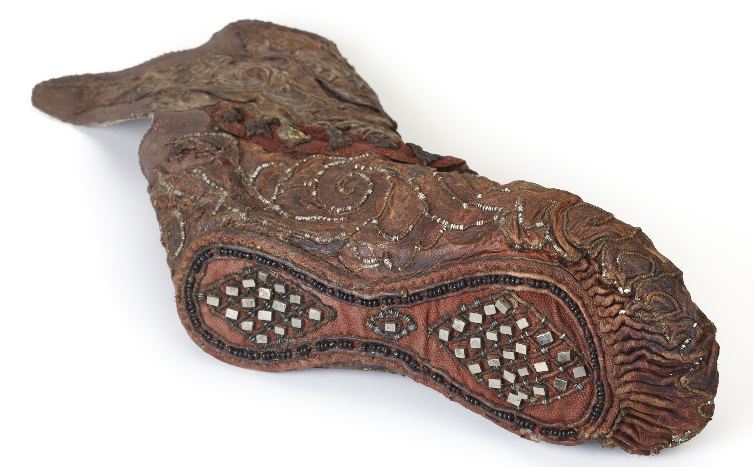 This woman’s shoe includes leather, tin, pyrite crystals, gold foil, and glass beads. 