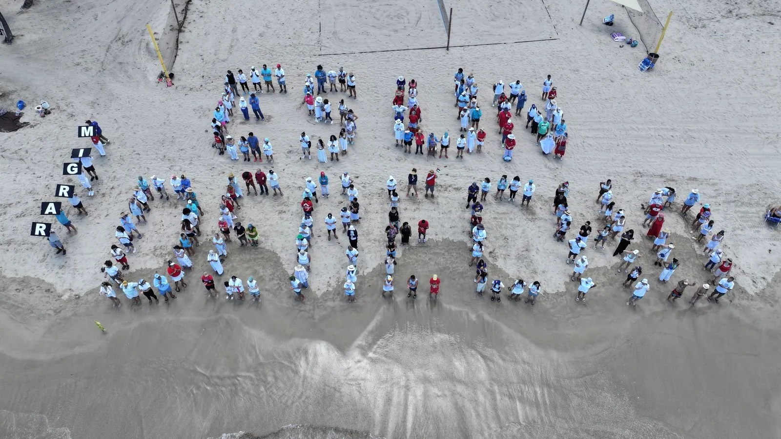 “Migrar es un derecho”: más de 200 personas forman frase en la playa en acto solidario con las comunidades inmigrantes