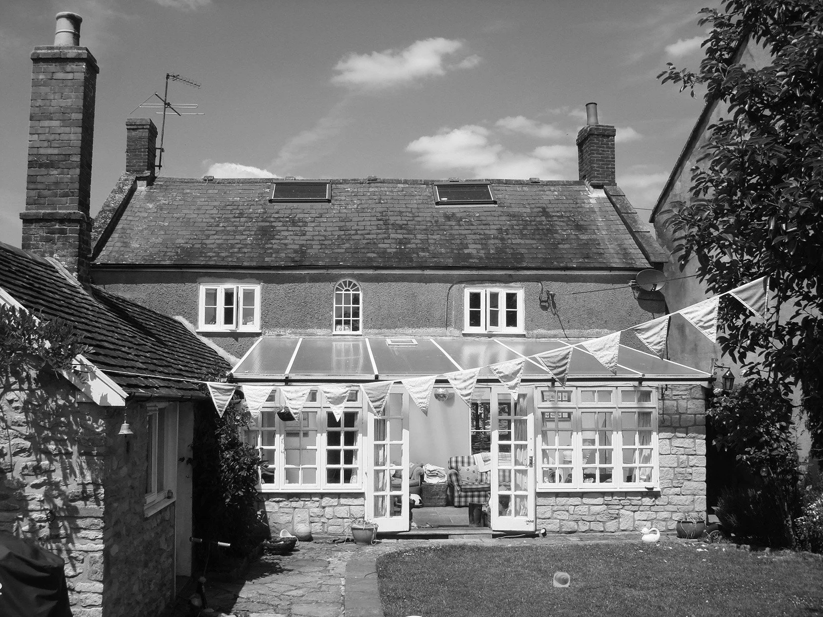 Image of the rear of a 19th century two storey detached house with a 20th century lean to conservatory.