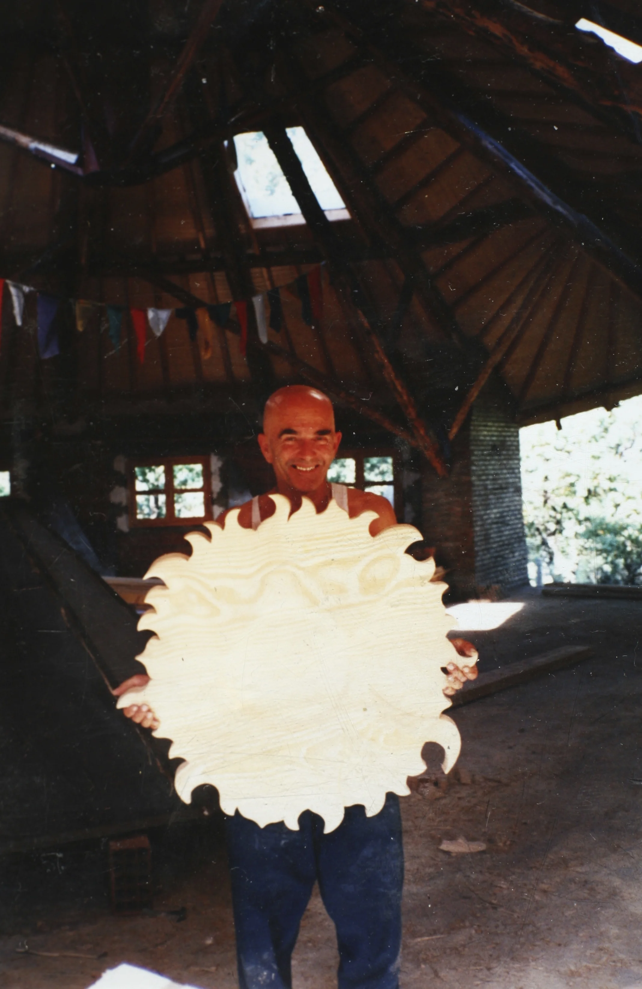 Philippe sujetando un sol de madera dentro de la sala circular en construcción.