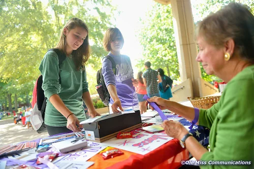 UM alumna Eunice Benton volunteers her time to hand out ribbons for National Coming Out Day activities at Ole Miss, an event co-sponsored by the Isom Center.