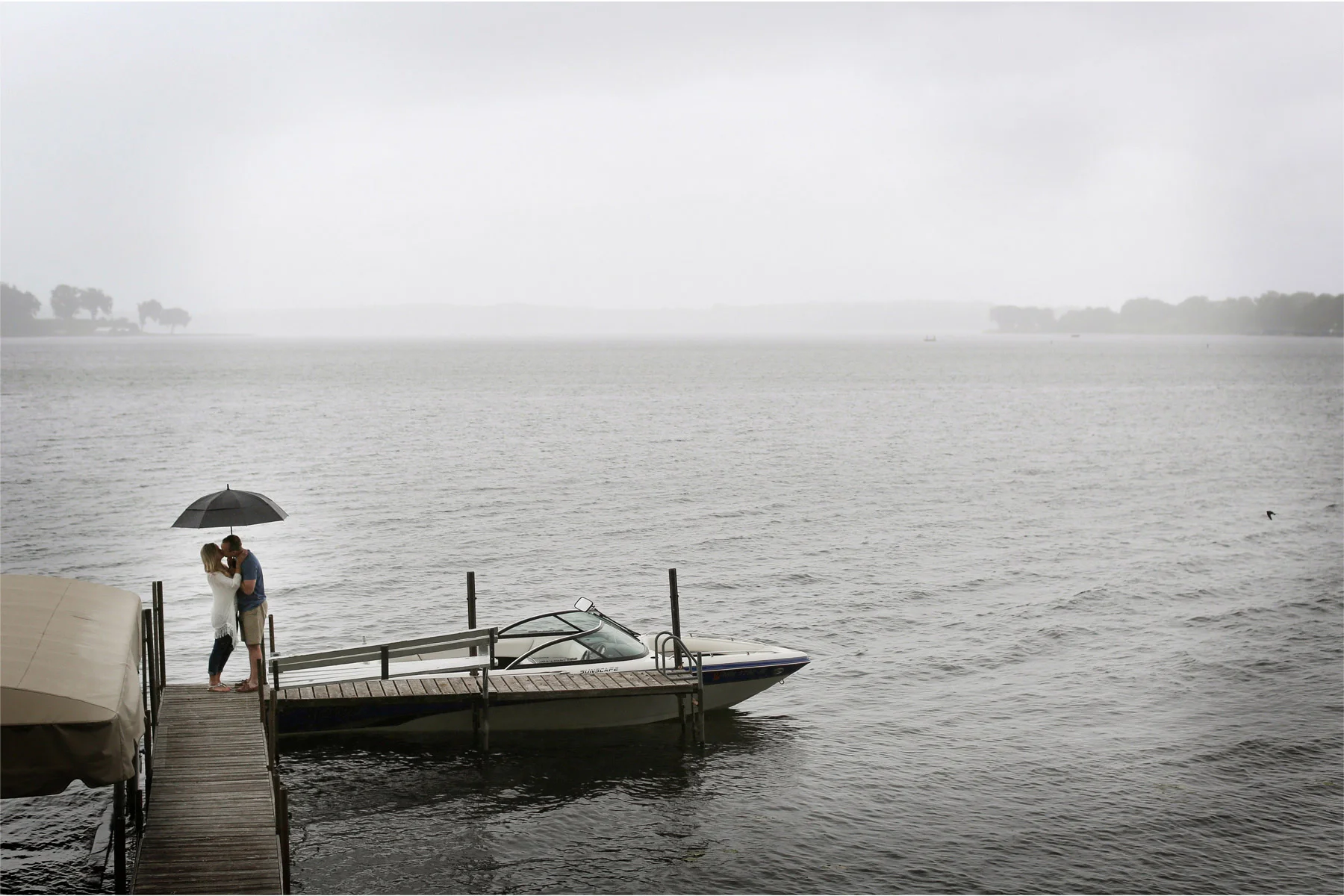06-Wayzata-Minnesota-Engagement-Photographer-by-Andrew-Vick-Photography-Summer-Lake-Minnetonka-Kiss-Rain-Umbrella-Speed-Boat-Ashley-&-Kasey.jpg