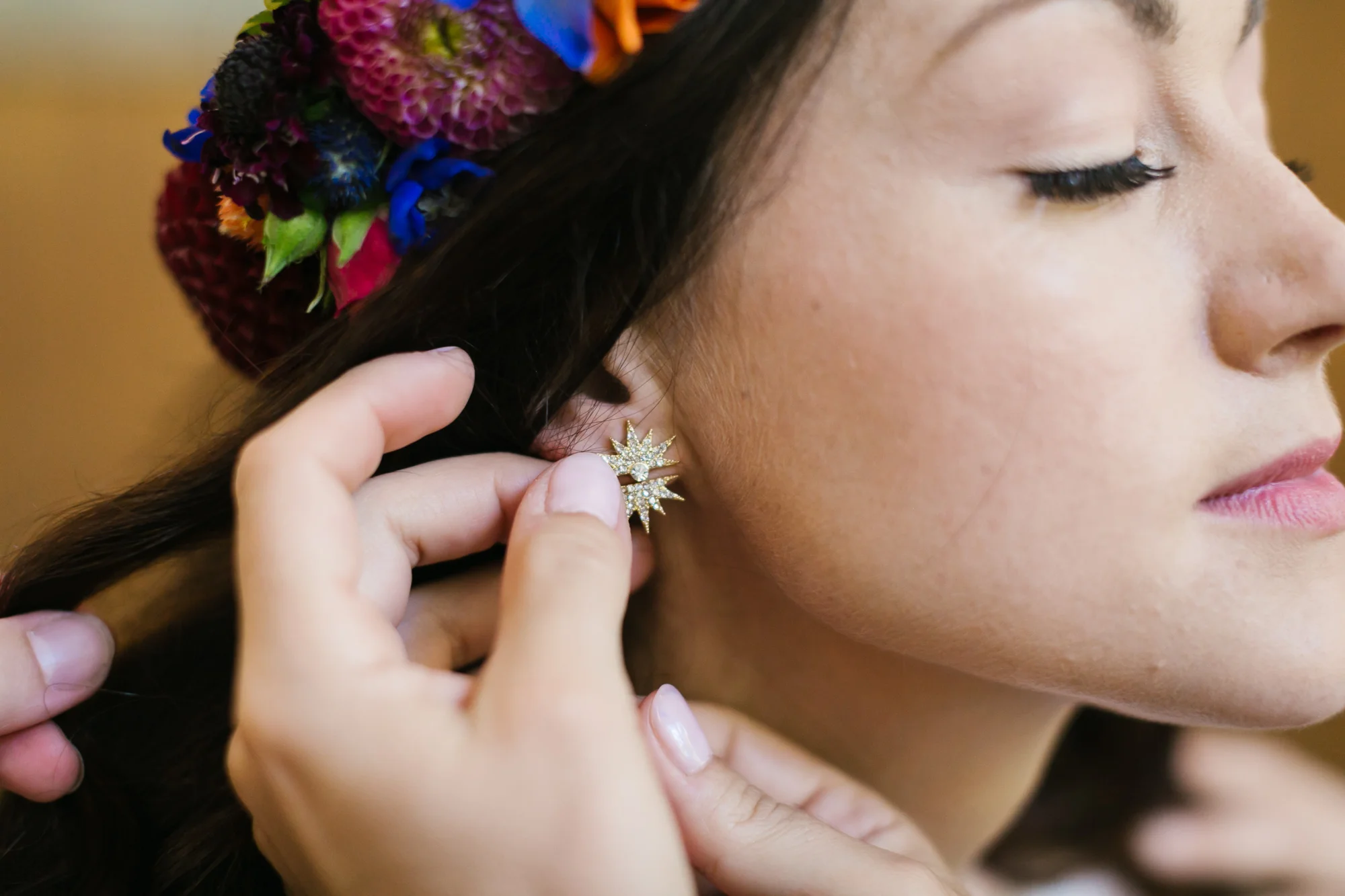 Bride's starburst earrings being put on