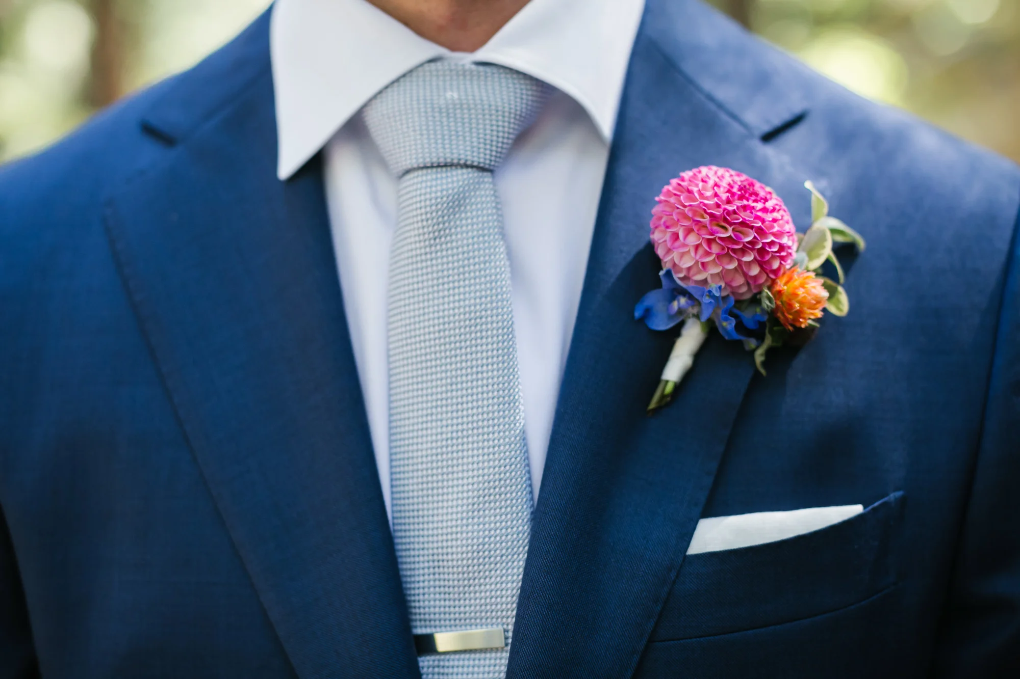 Groom's blue suit with pink dahlia boutonniere